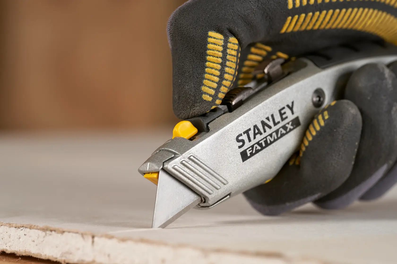 Stanley 0-10-789 taglierino in uso su cartongesso, foto ravvicinata con mano guantata.