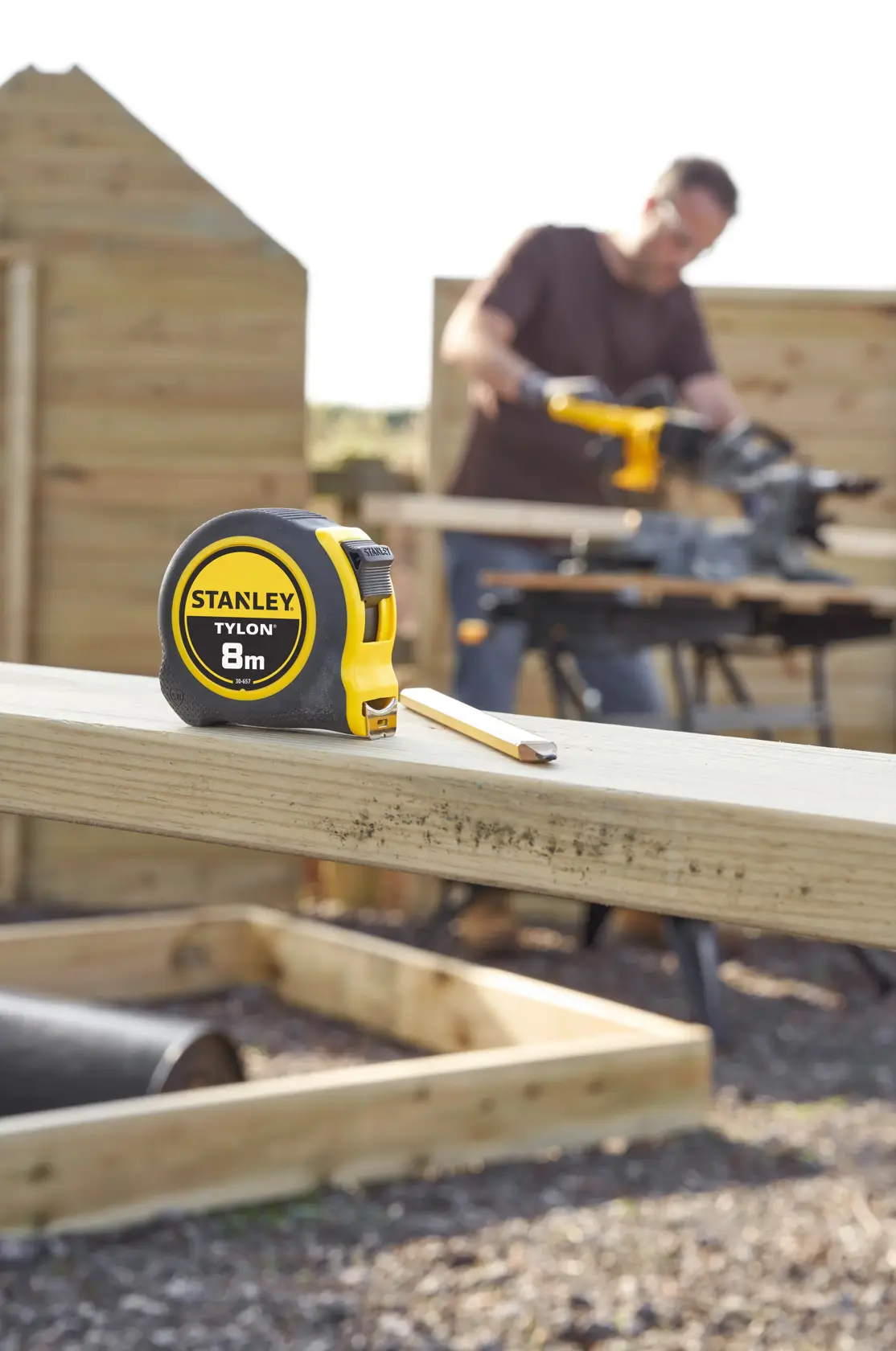 STANLEY 0-30-657 metro a nastro con custodia gialla e nera, 8m, su trave in cantiere.
