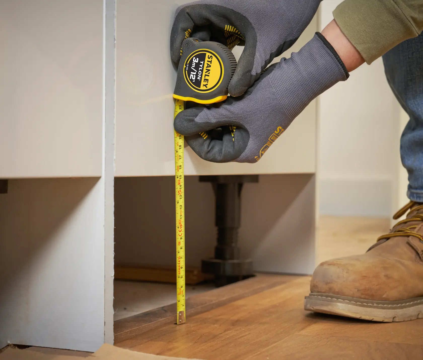 STANLEY 0-30-686 metro a nastro giallo usato per misura verticale su mobile su pavimento in legno.