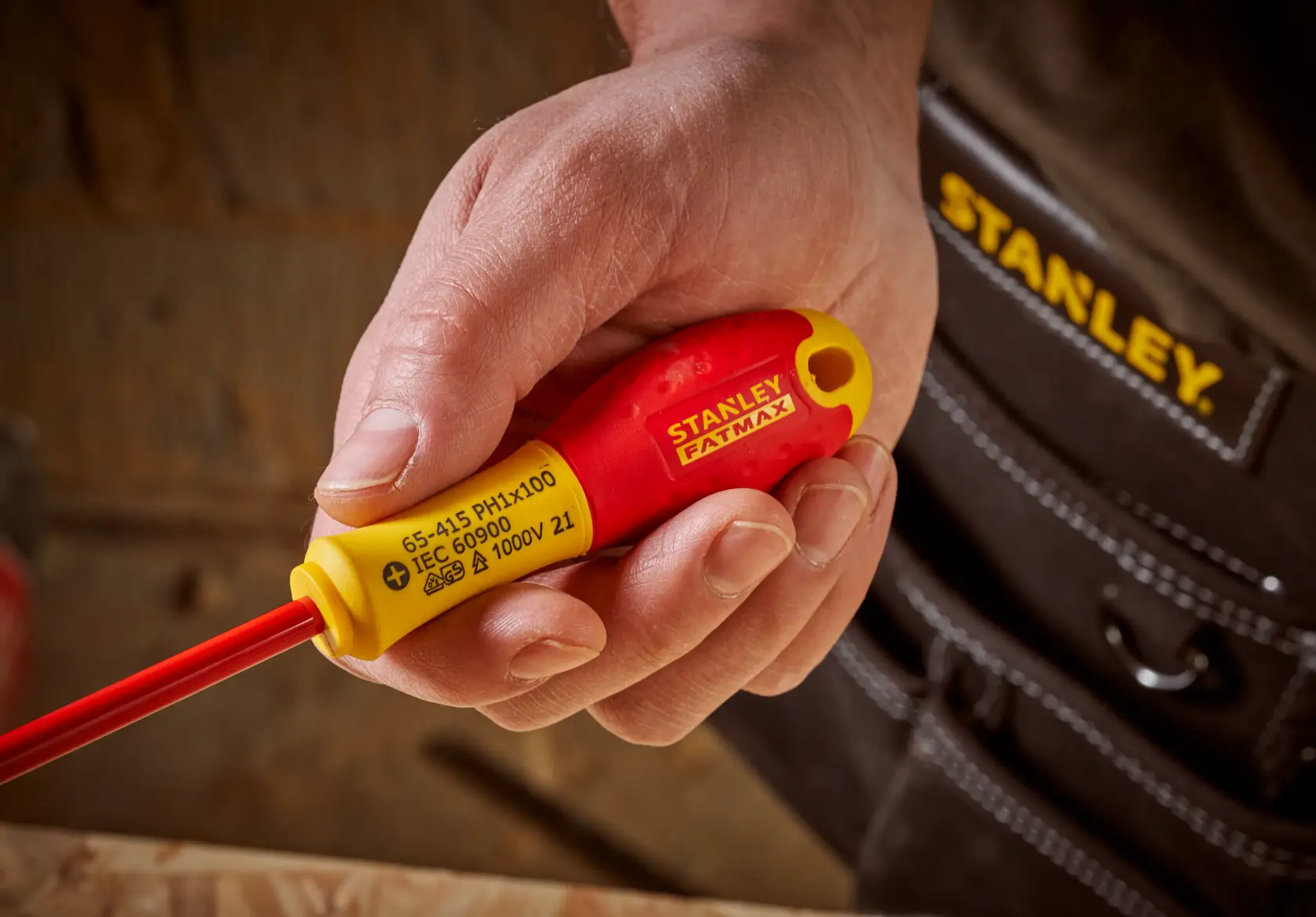 Foto di cacciavite isolato STANLEY 0-65-415 con manico rosso e giallo, tenuto in mano, vista ravvicinata.
