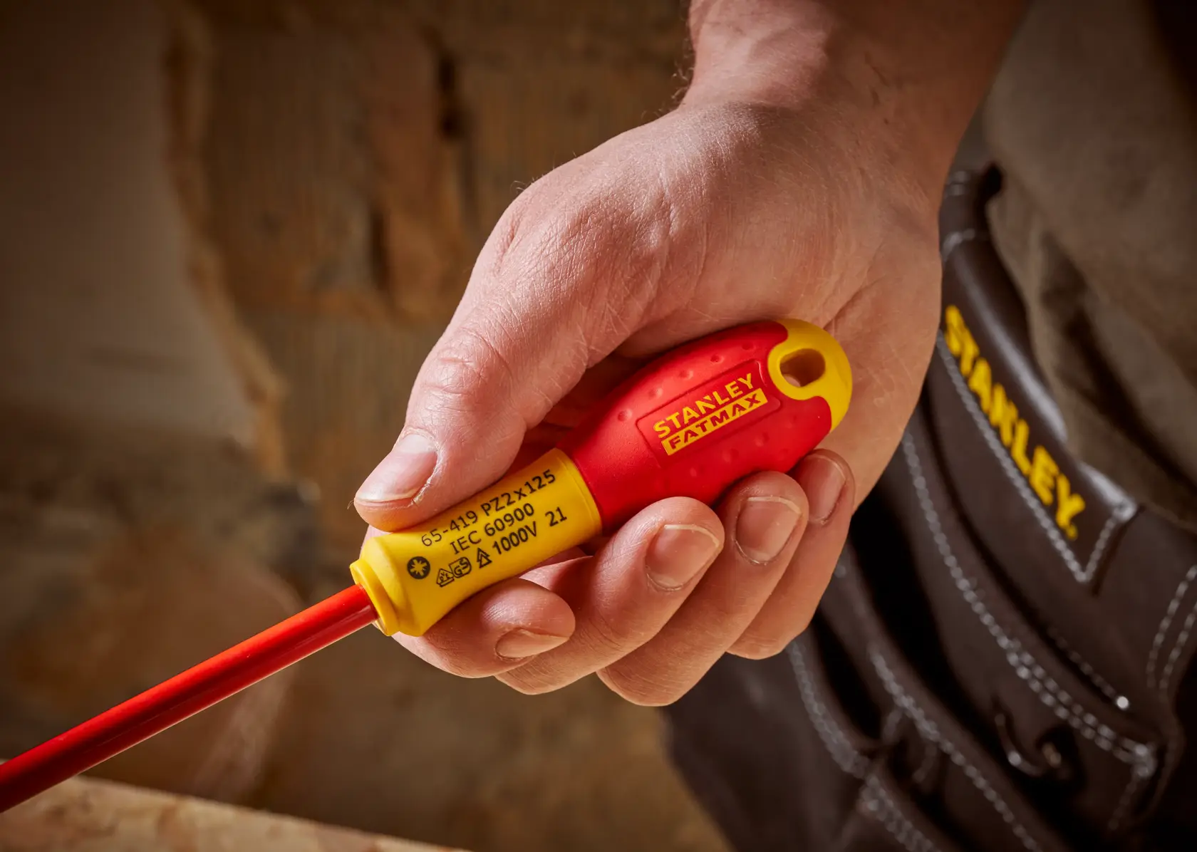 STANLEY 0-65-419 giravite isolato con manico rosso e giallo tenuto in mano, vista ravvicinata.