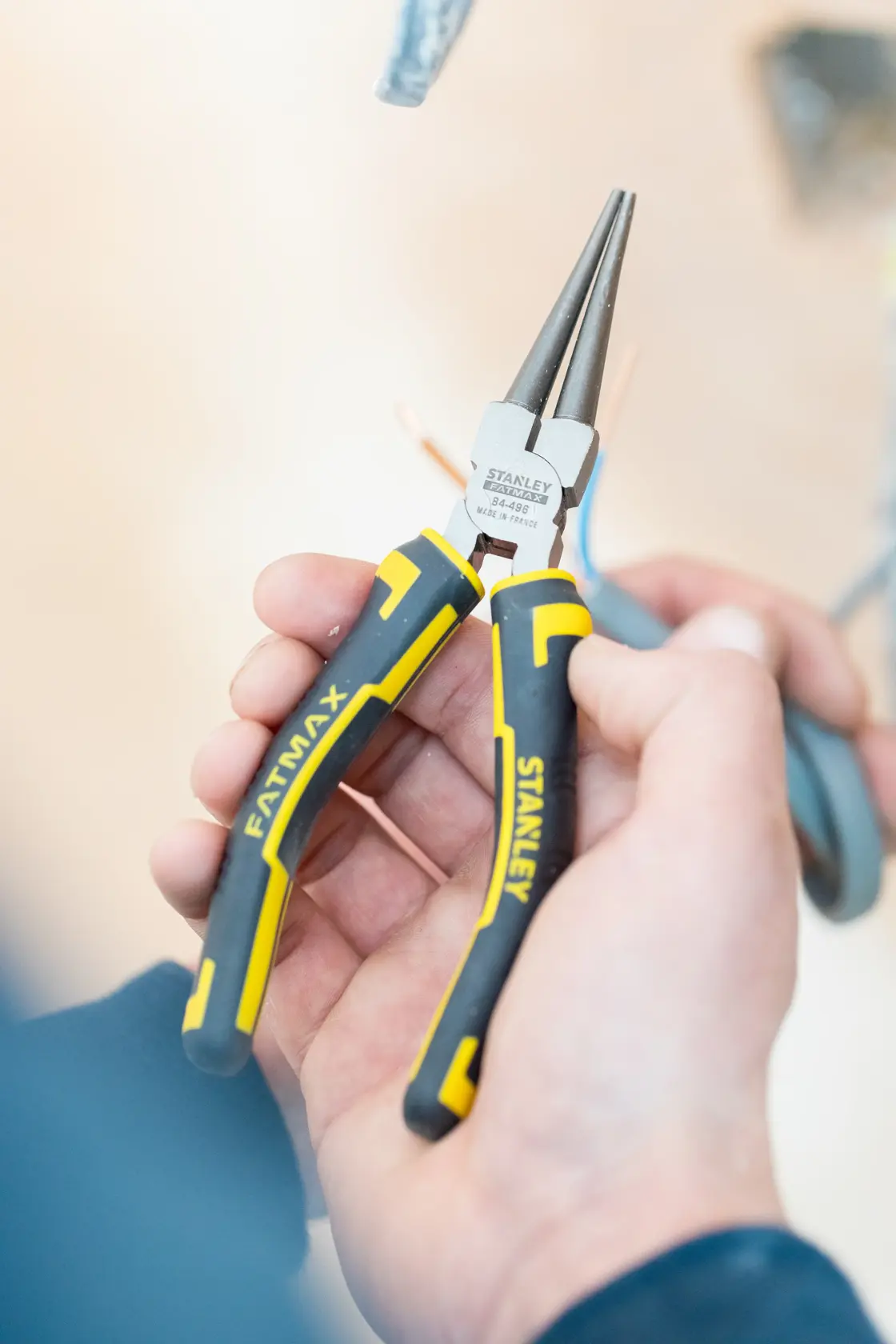 STANLEY 0-84-496 FATMAX pinza a becchi lunghi con manico nero e giallo, primo piano in mano.