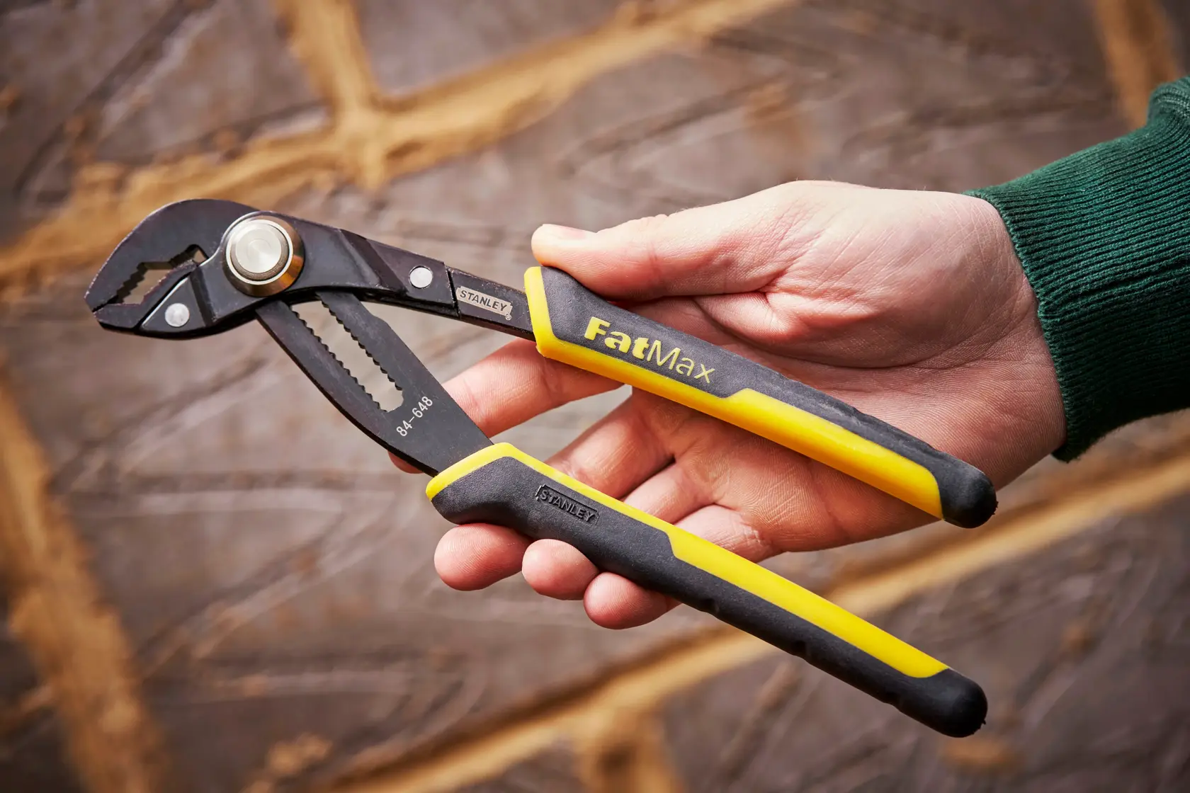STANLEY 0-84-648 pinza per pompe FatMax, manici nero e giallo, tenuta in mano.