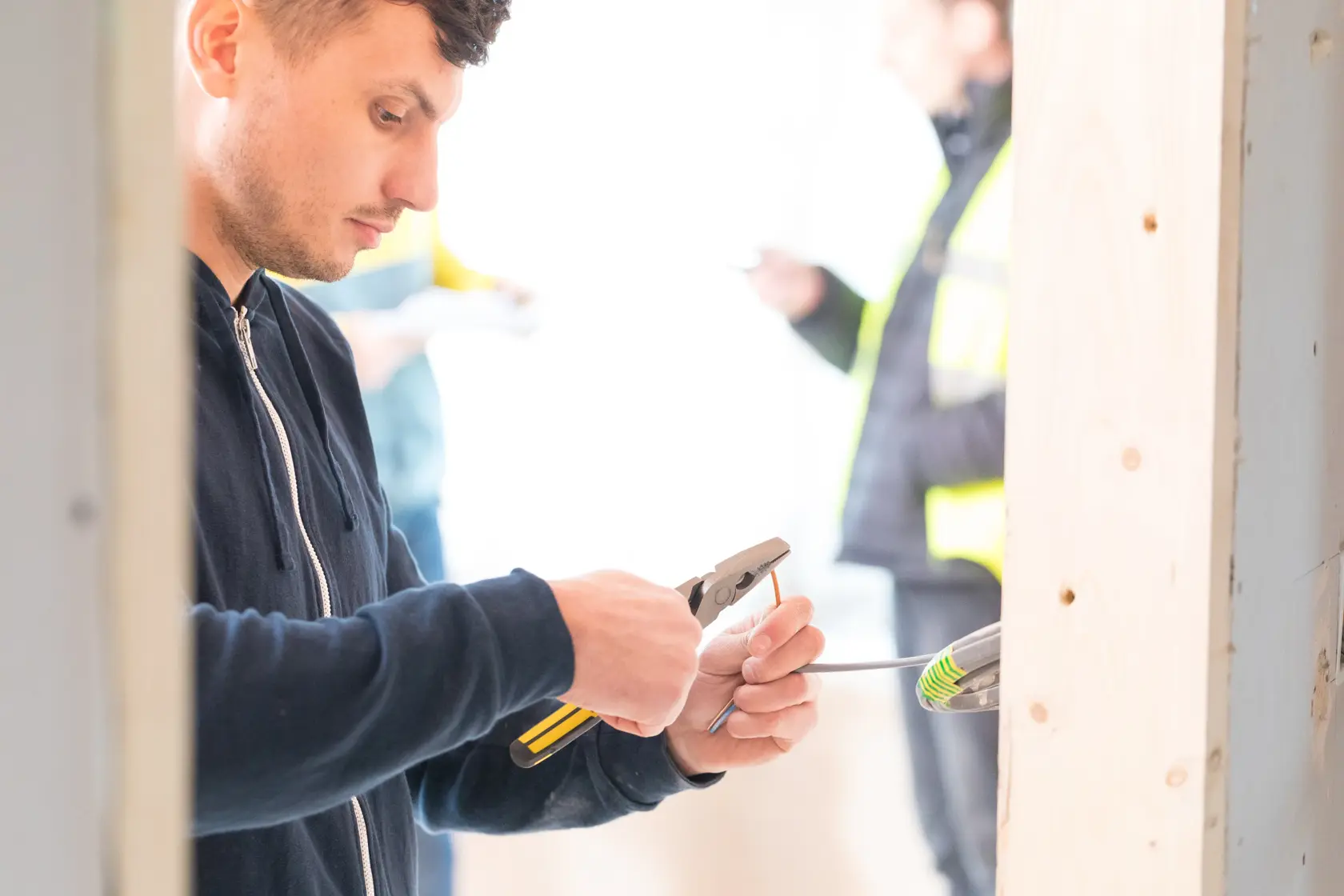 Pinza STANLEY 0-89-868 utilizzata da operaio per spelare cavo in ambiente di costruzione.