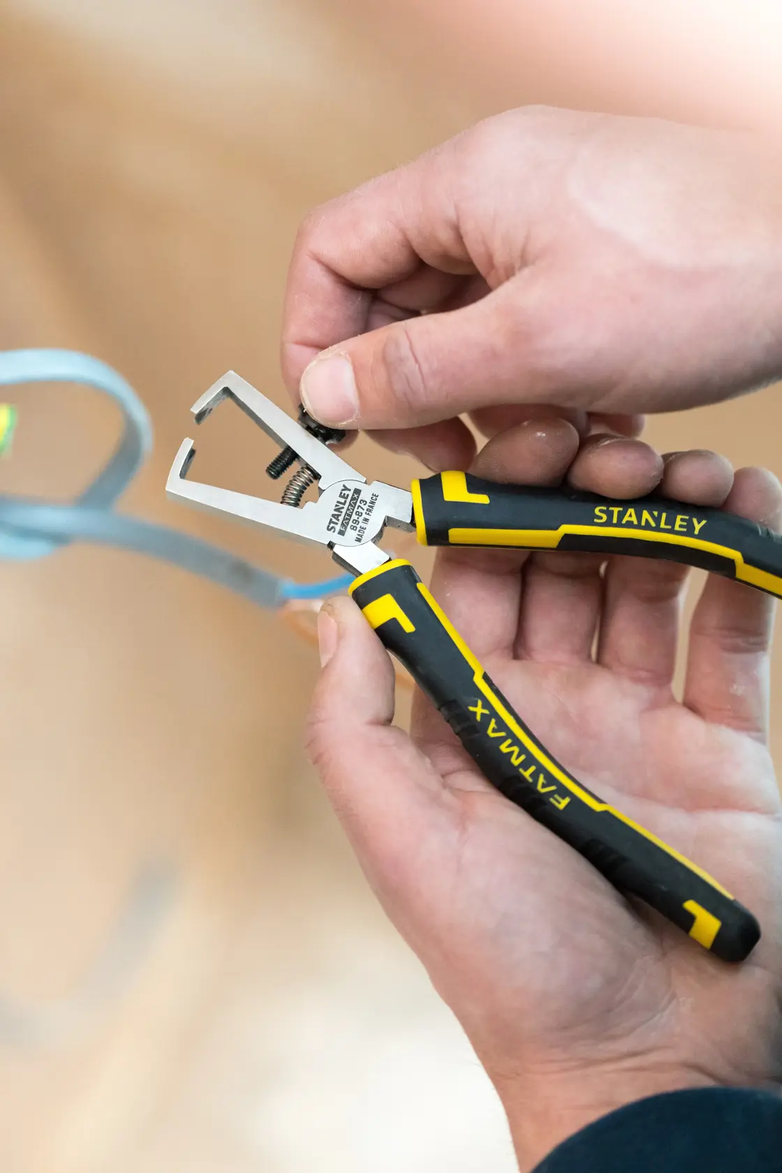 Pinza STANLEY 0-89-873 nera e gialla con impugnatura FATMAX tenuta in mano, vista ravvicinata.