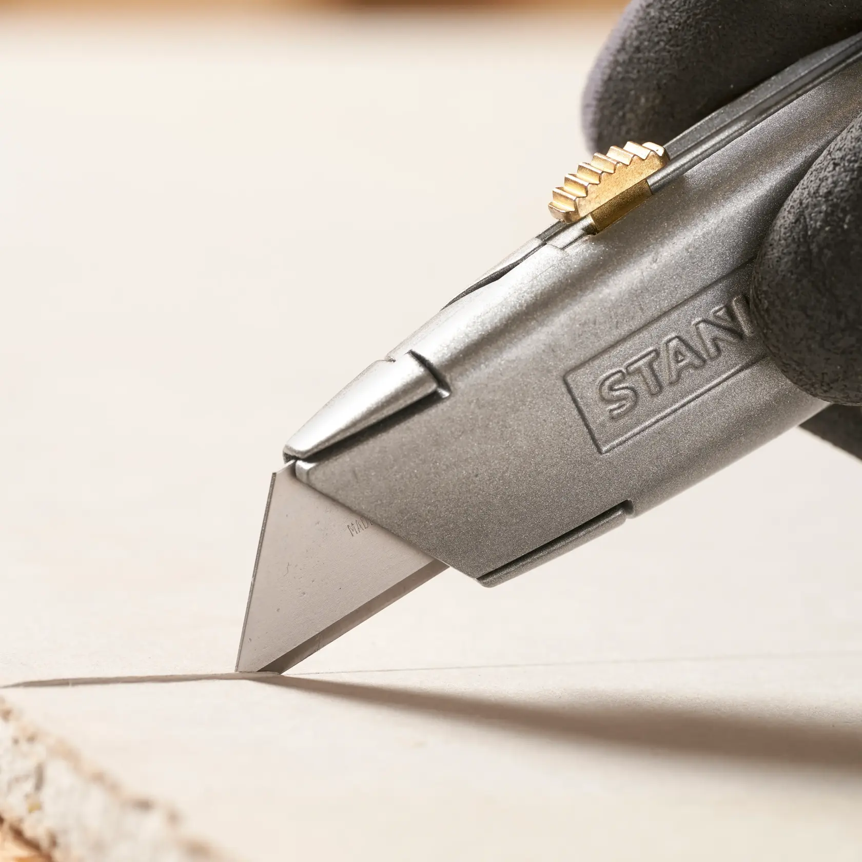 STANLEY 1-11-921 coltello da lavoro primo piano taglia materiale, corpo argentato con cursore in ottone.