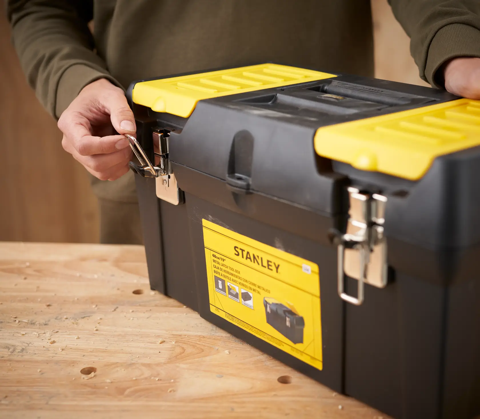 STANLEY 1-92-066 cassetta degli attrezzi con coperchio giallo e chiusure metalliche, angolo frontale, su tavolo di legno.