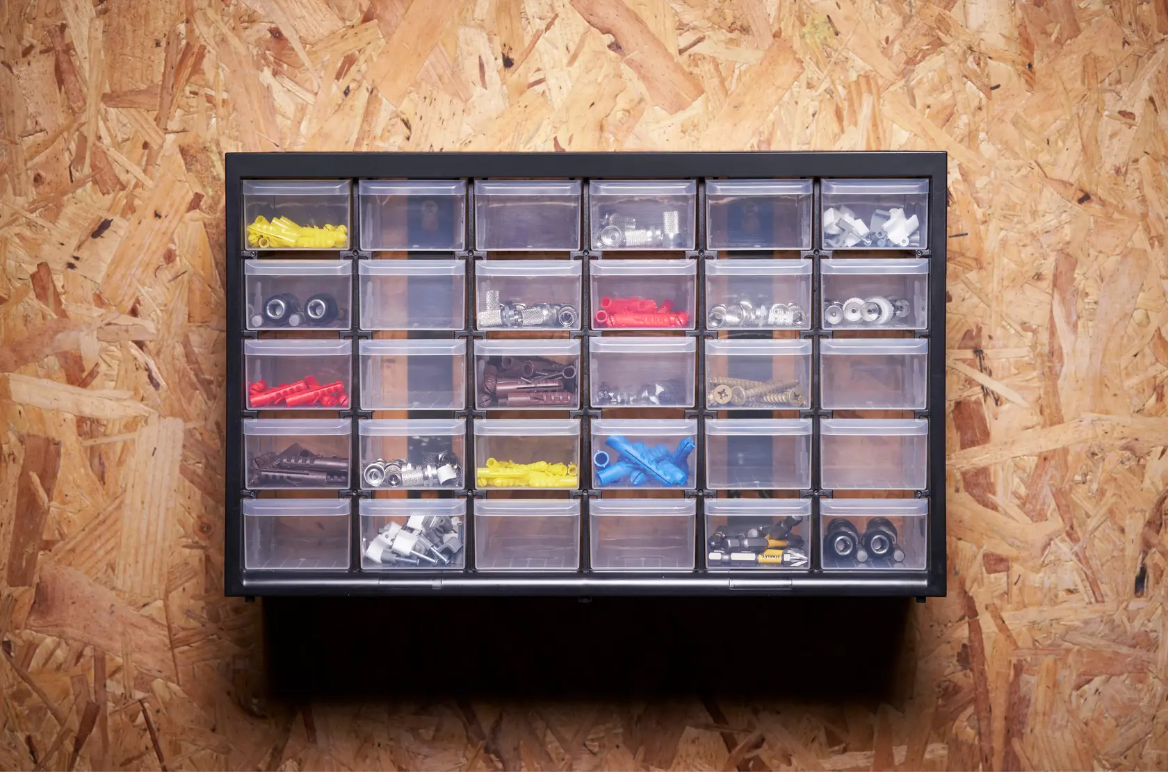 STANLEY 1-93-980 organizzatore con 24 cassetti trasparenti contenenti minuteria assortita, vista frontale a parete.