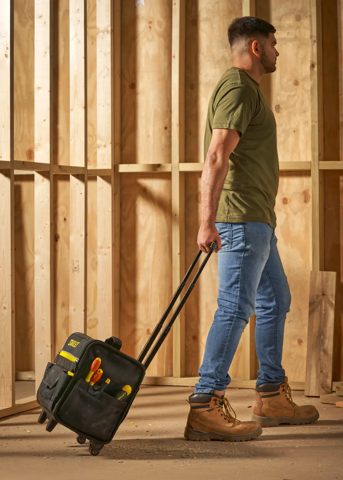 STANLEY 1-97-515 borsa portautensili con ruote e utensili, trasportata da persona in cantiere.