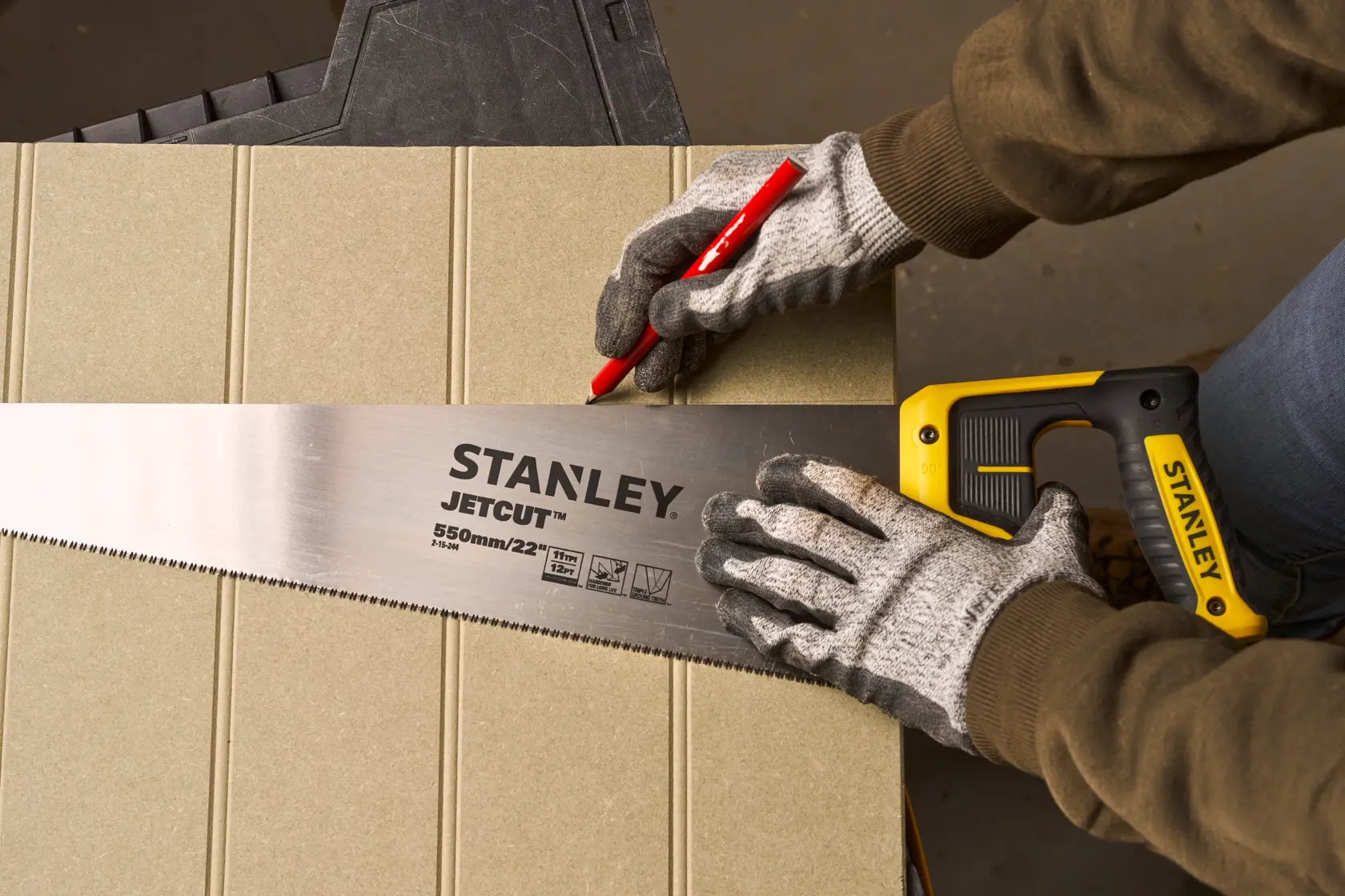 Foto del segaccio STANLEY 2-15-244 con manico giallo e lama JETCUT, usato per segnare una linea sul legno.