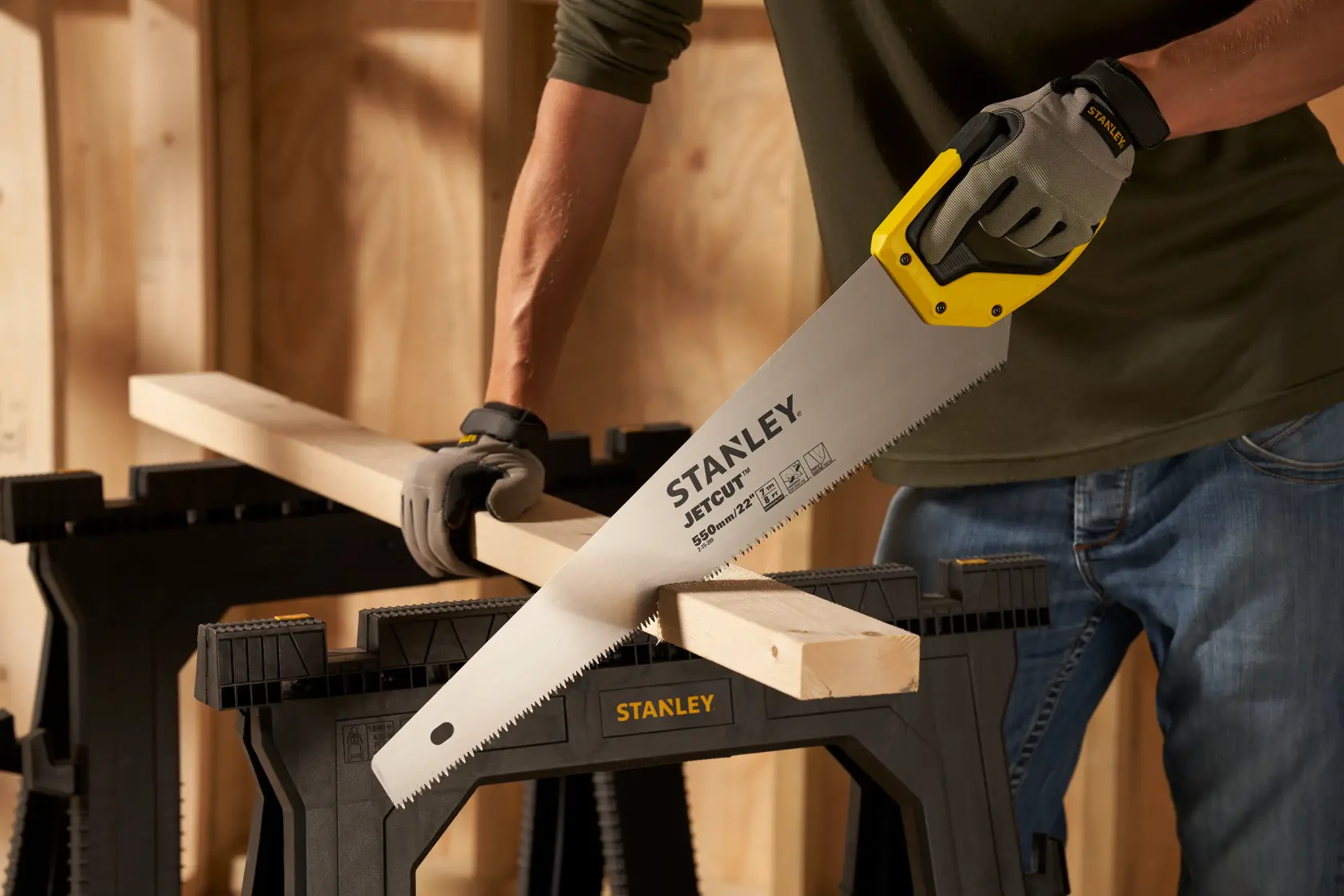 Stanley 2-15-289 sega manuale con manico giallo taglia legno su cavalletto nero, sfondo officina.