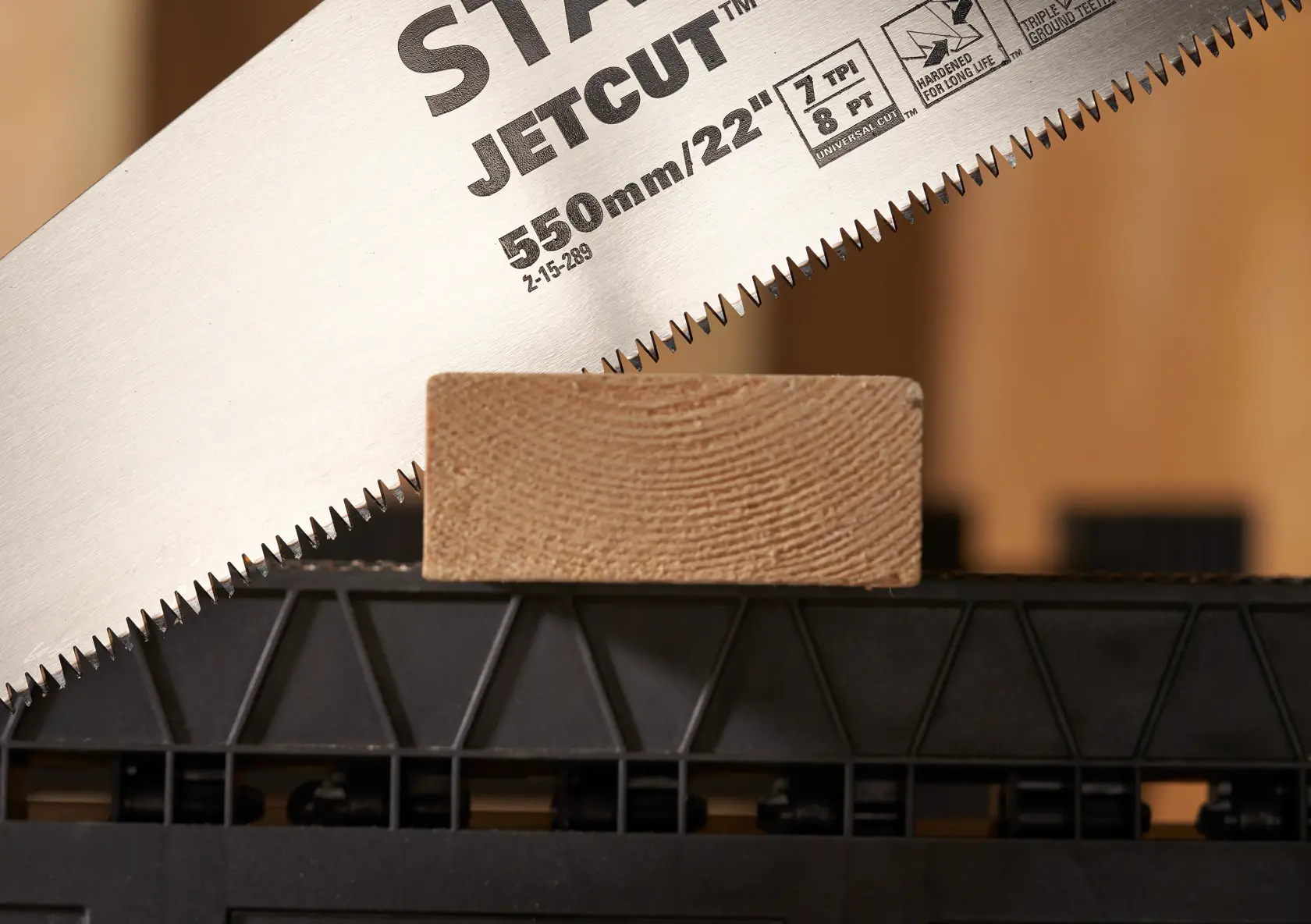 STANLEY 2-15-289 sega a mano in primo piano tagliando legno, fotografia, vista angolata su lama e denti.
