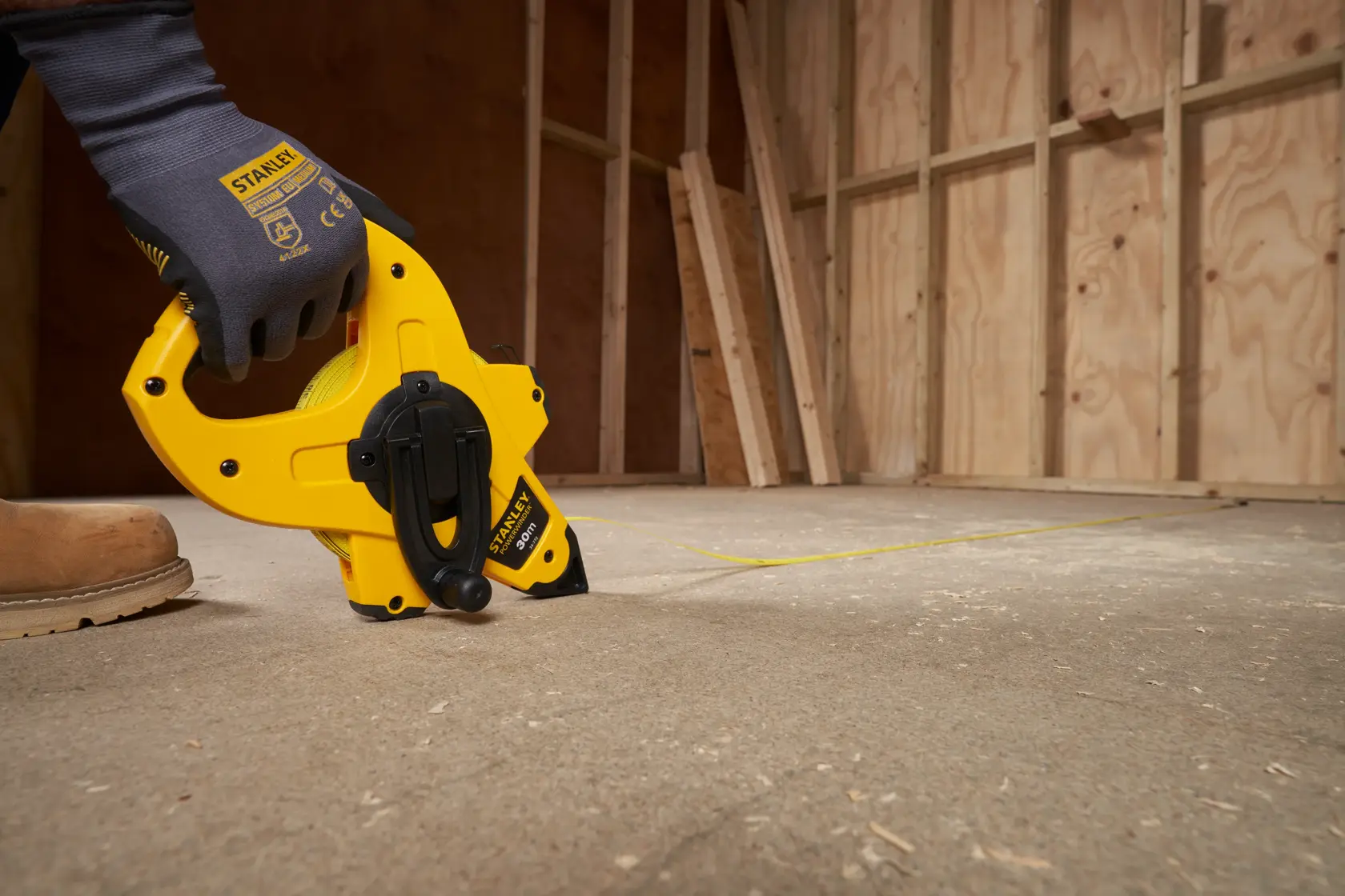 Stanley 2-34-772 metro a nastro con telaio aperto utilizzato per segnare linee su un pavimento di cantiere.