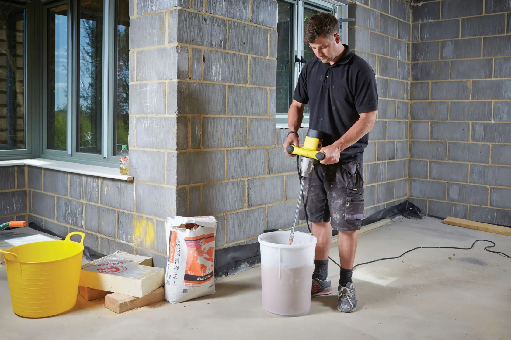 STANLEY FME190-QS miscelatore a palette usato per mescolare materiali in un secchio bianco in cantiere.
