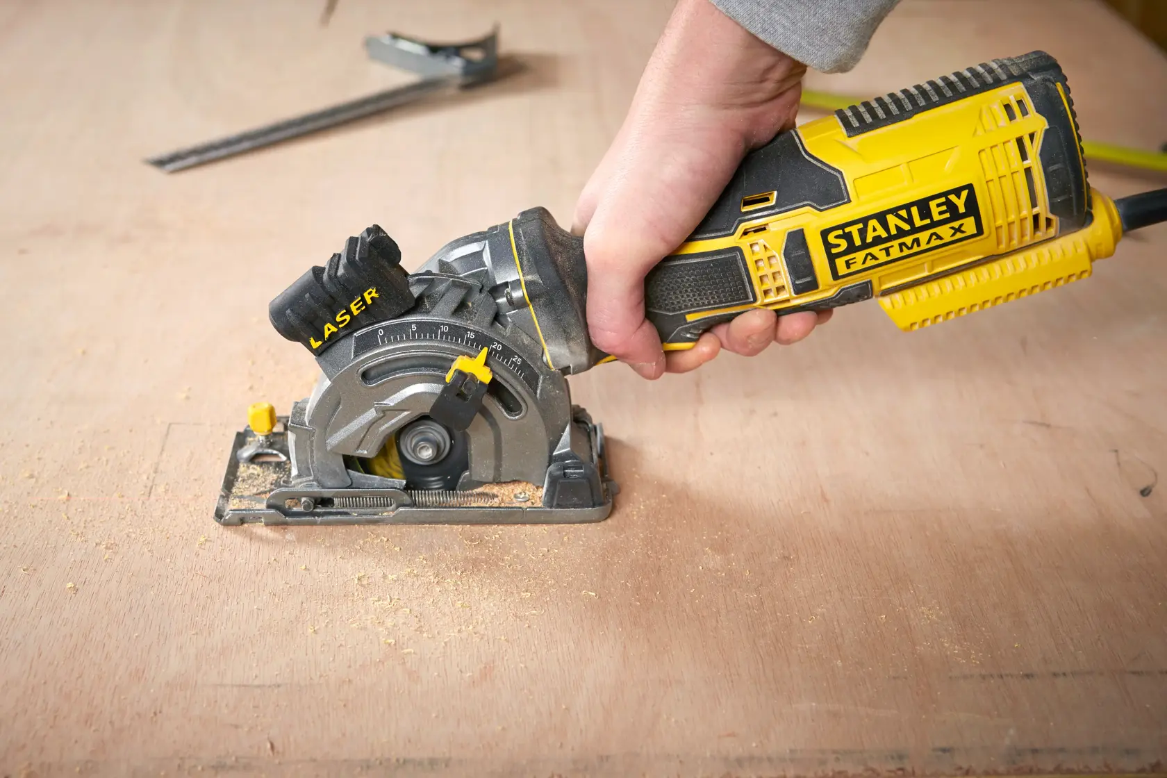 Fotografia della sega circolare portatile STANLEY FME380K con guida laser su superficie di legno.