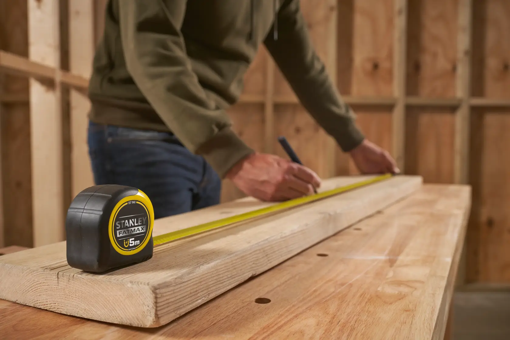 STANLEY FMHT0-33864 metro a nastro su legno in officina, persona segna una misura.