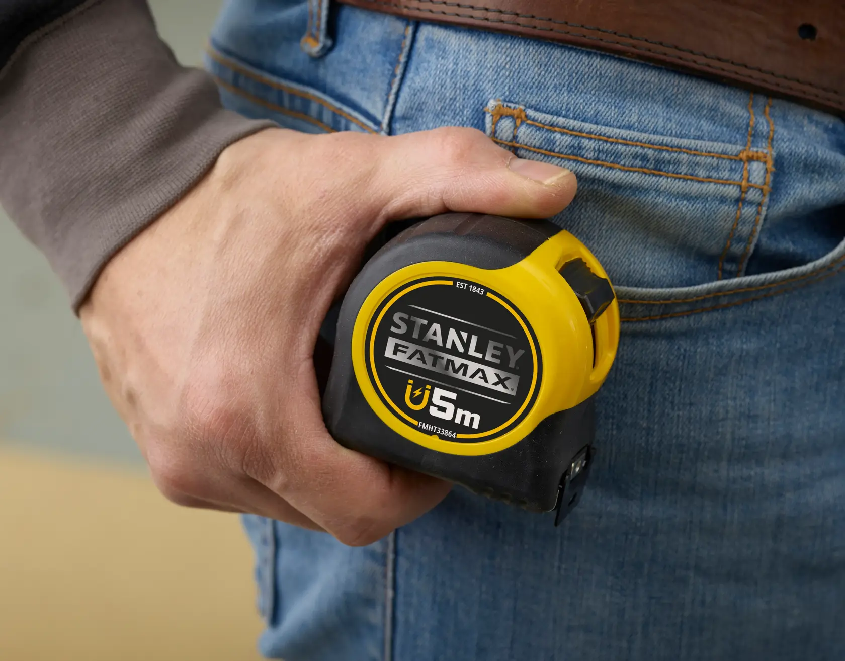 Stanley FMHT0-33864 metro tenuto in mano, giallo e nero, foto ravvicinata.