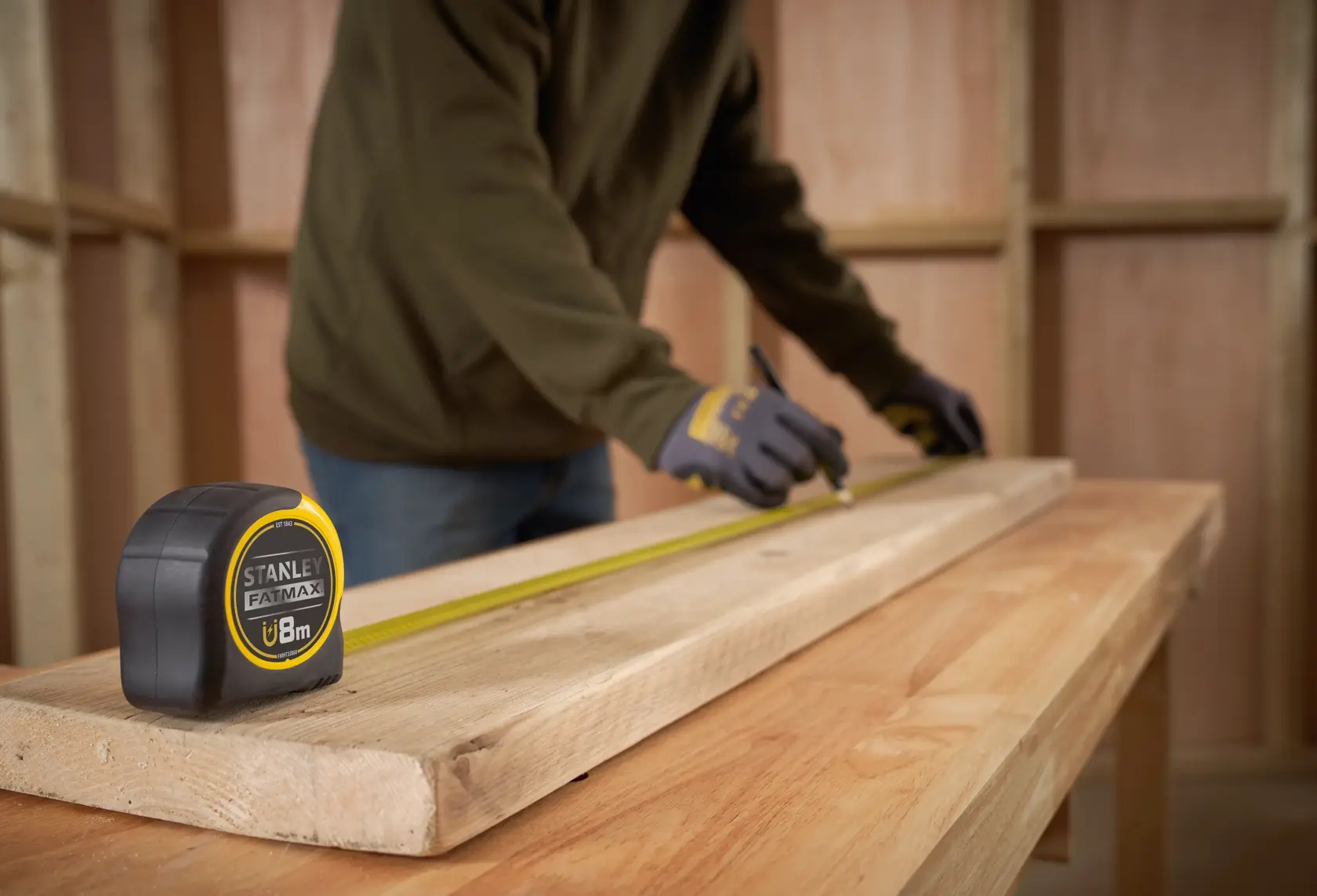 STANLEY FMHT0-33868 FATMAX metro a nastro su trave in legno in laboratorio, persona segna le misure.