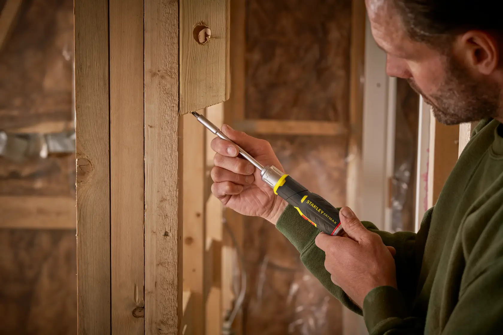 Foto di cacciavite STANLEY FMHT0-62691 usato su struttura in legno in ambiente di costruzione.