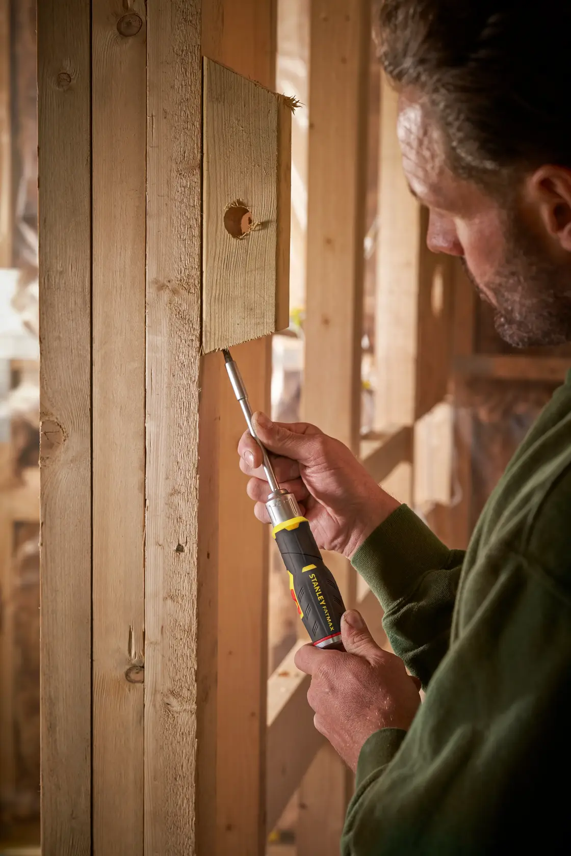 Foto del cacciavite a cricchetto STANLEY FMHT0-62691 utilizzato su una struttura in legno.