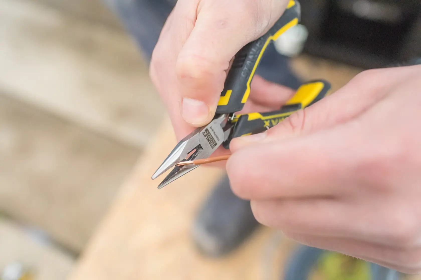 Stanley FMHT0-80517 pinza con manico giallo e nero che taglia filo di rame, foto ravvicinata.