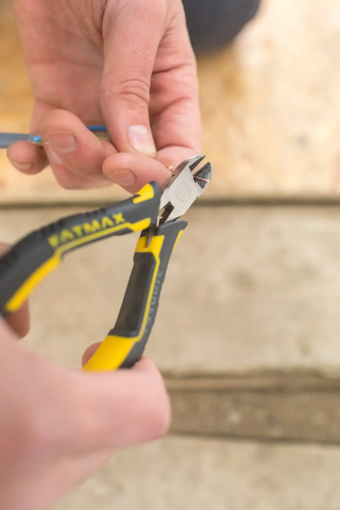 STANLEY FMHT0-80518 pinza diagonale che taglia un filo, fotografia ravvicinata dell’utensile nero e giallo.