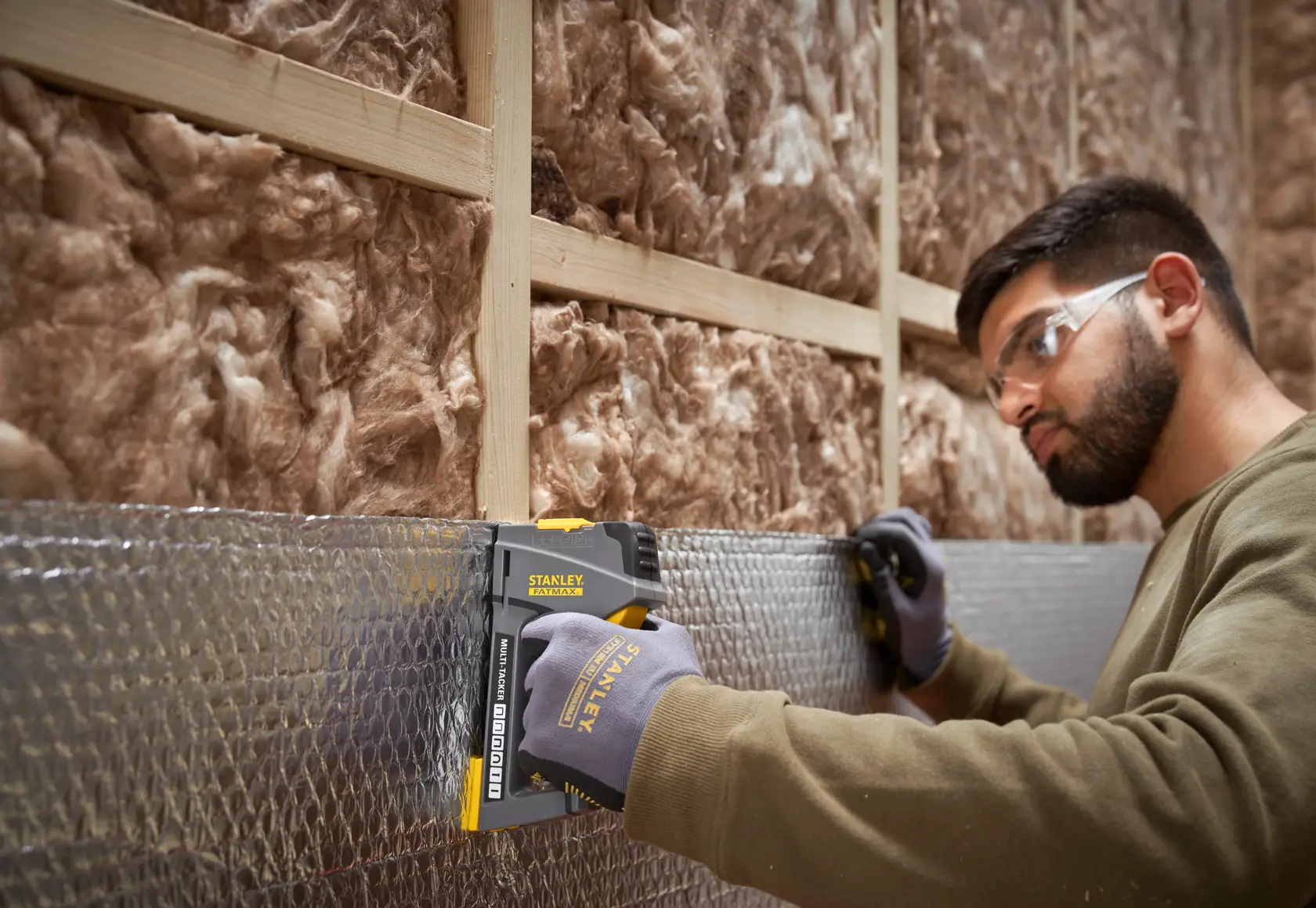 STANLEY FMHT6-70868 graffatrice usata su isolante da operaio con guanti, mostrata in cantiere.