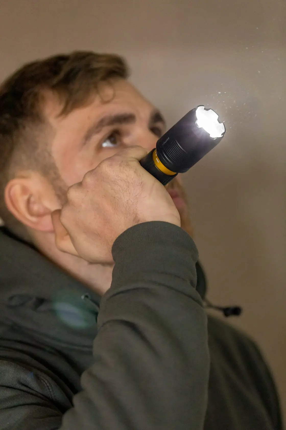 Fotografia della torcia STANLEY FMHT81511-0 tenuta da una persona, fascio di luce visibile all'interno.