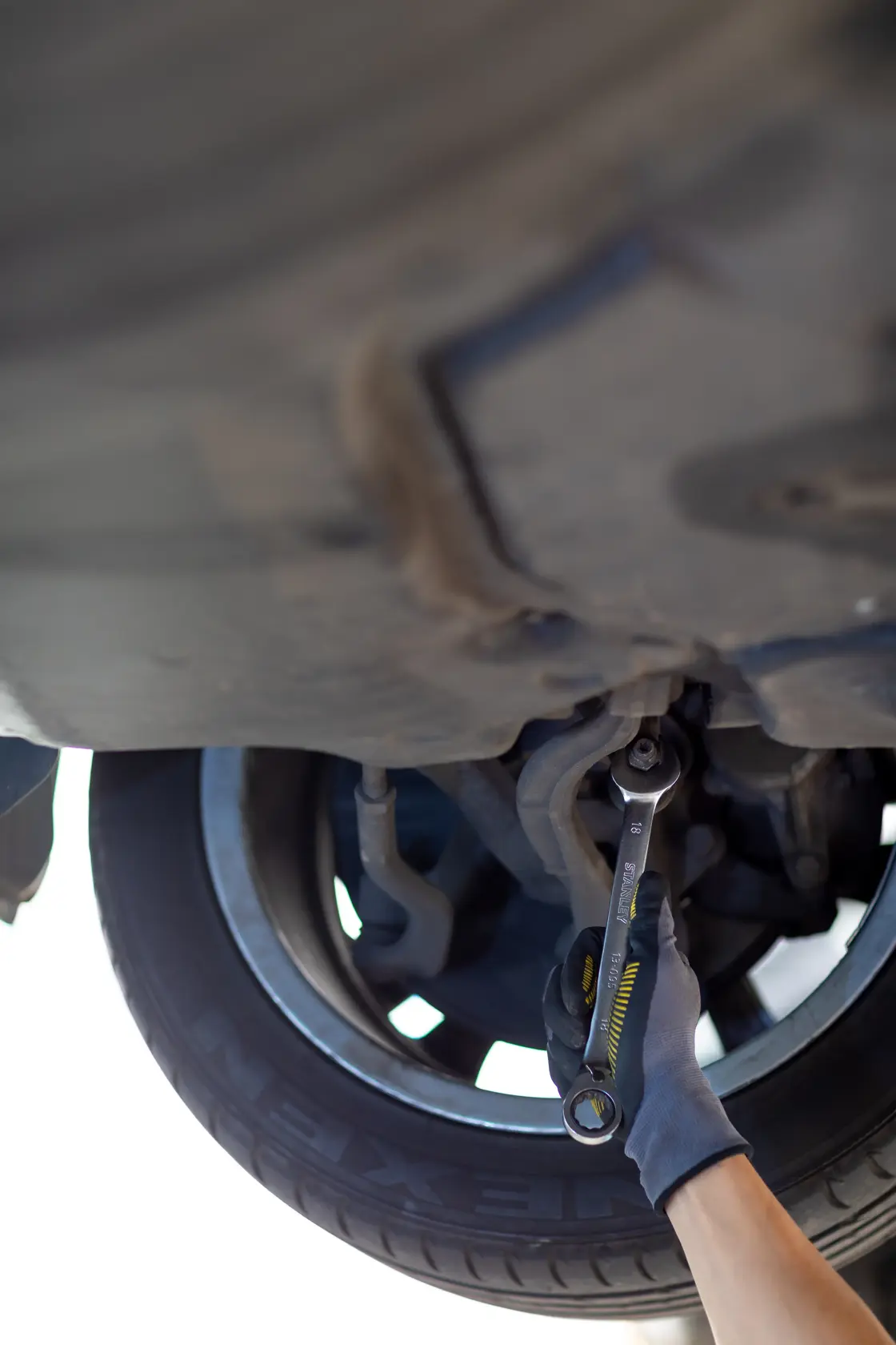 Chiave STANLEY FMMT13089-0 usata sotto l'auto vicino alla ruota, fotografia di utensile per riparazione auto.