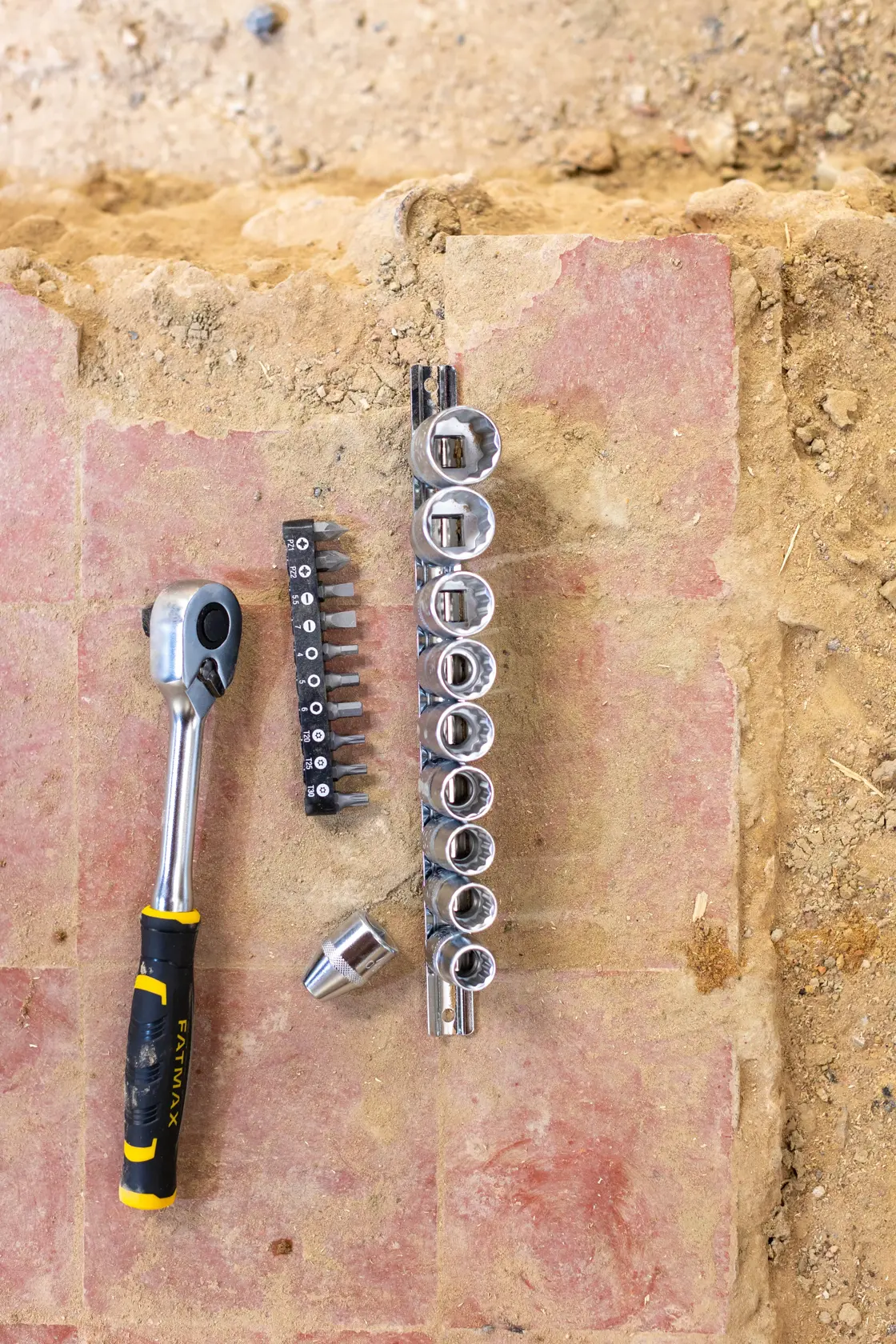 Set di bussole e inserti STANLEY FMMT82679-0 con cricchetto, vista dall'alto su superficie da cantiere.