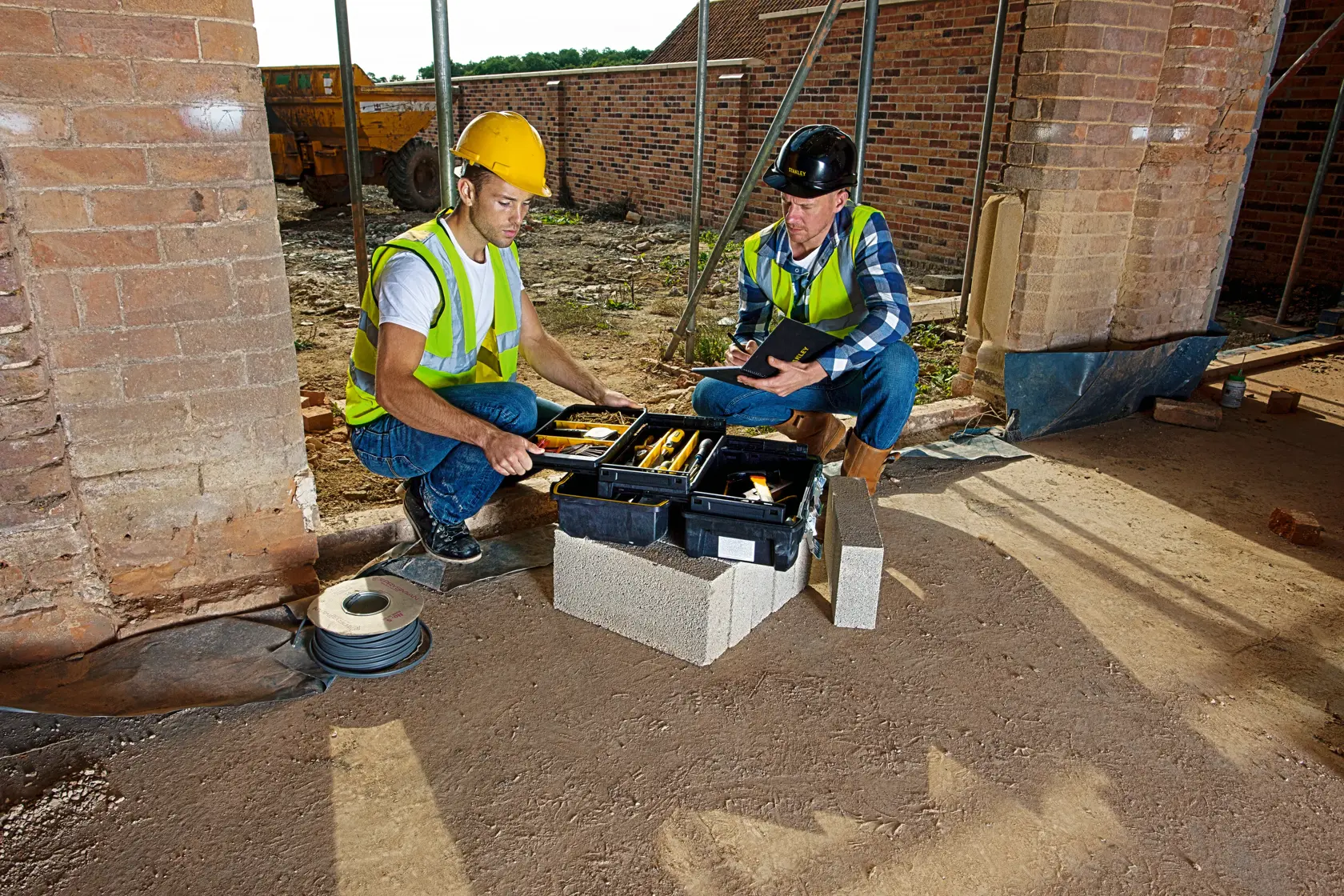 Cassetta degli attrezzi STANLEY FMST1-71219 aperta in cantiere, con utensili manuali, usata da due operai.