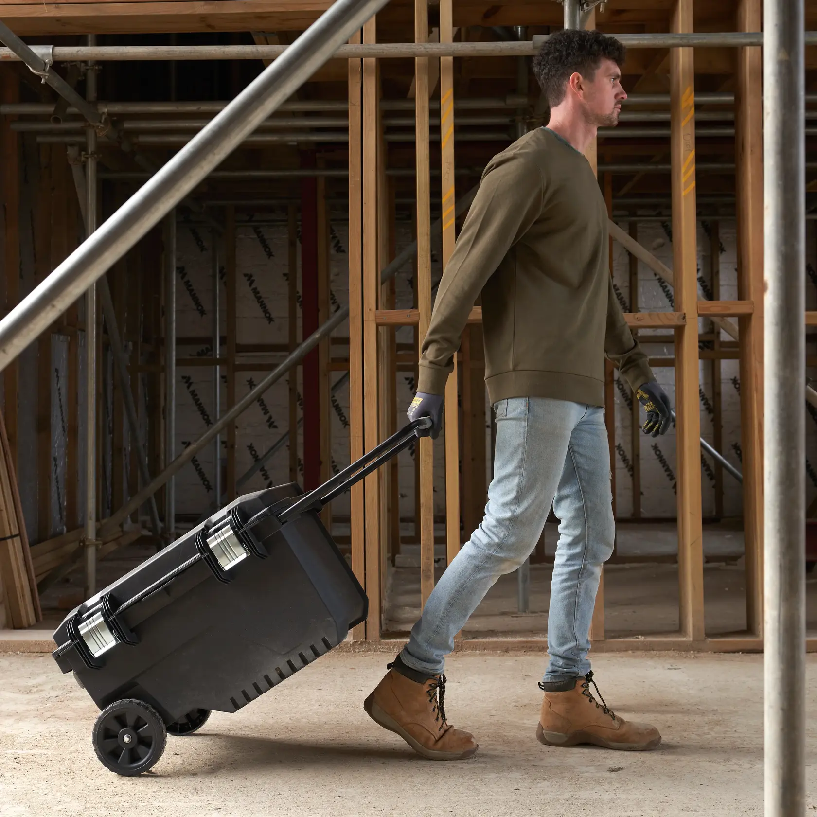 STANLEY FMST1-73601 cassetta degli attrezzi su ruote con manico, trainata in un cantiere.