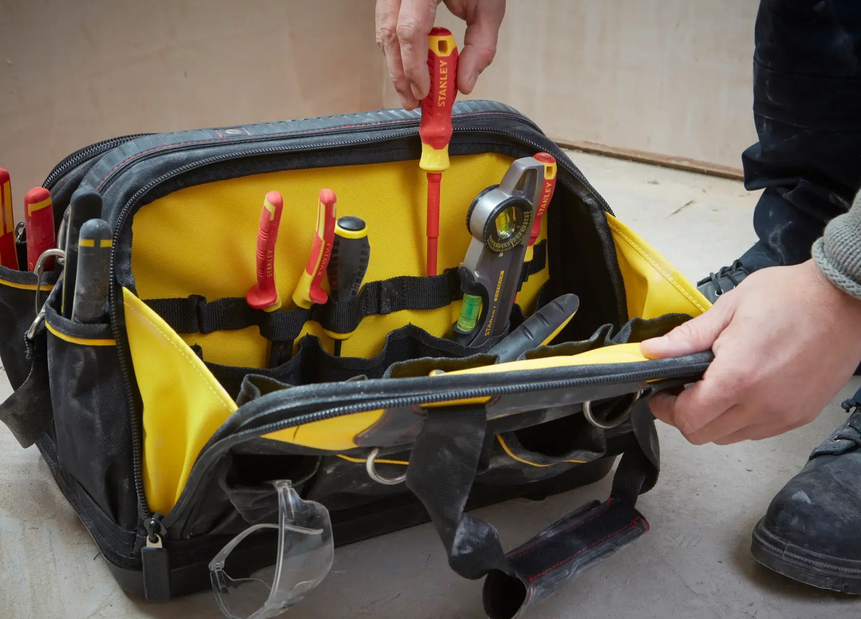 Borsa porta attrezzi STANLEY FMST1-73607 con interno giallo, mano che inserisce un cacciavite, attrezzi visibili.