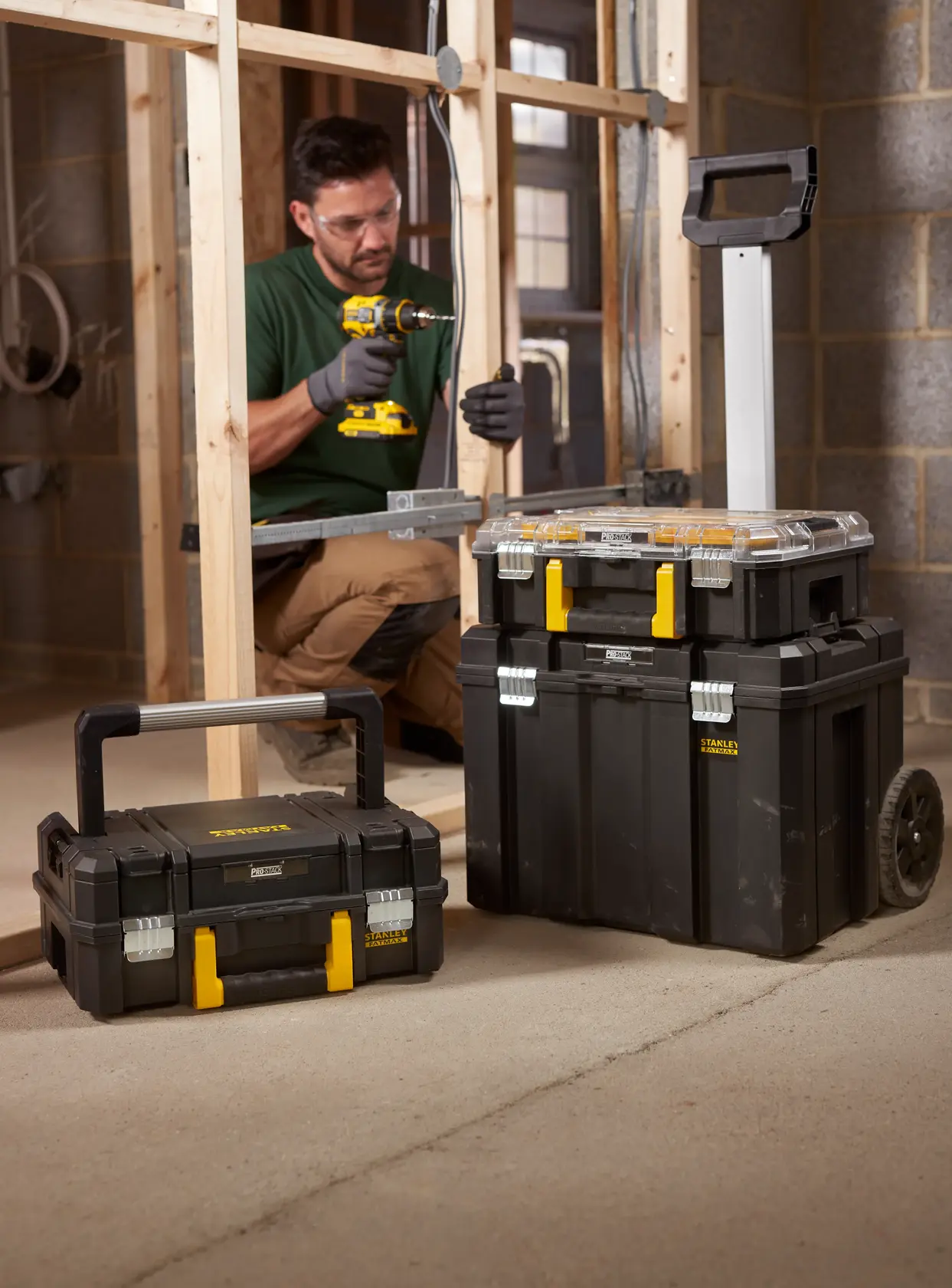 STANLEY FMST1-75753 cassette portautensili modulari nere con chiusure gialle, una con ruote, in un cantiere.