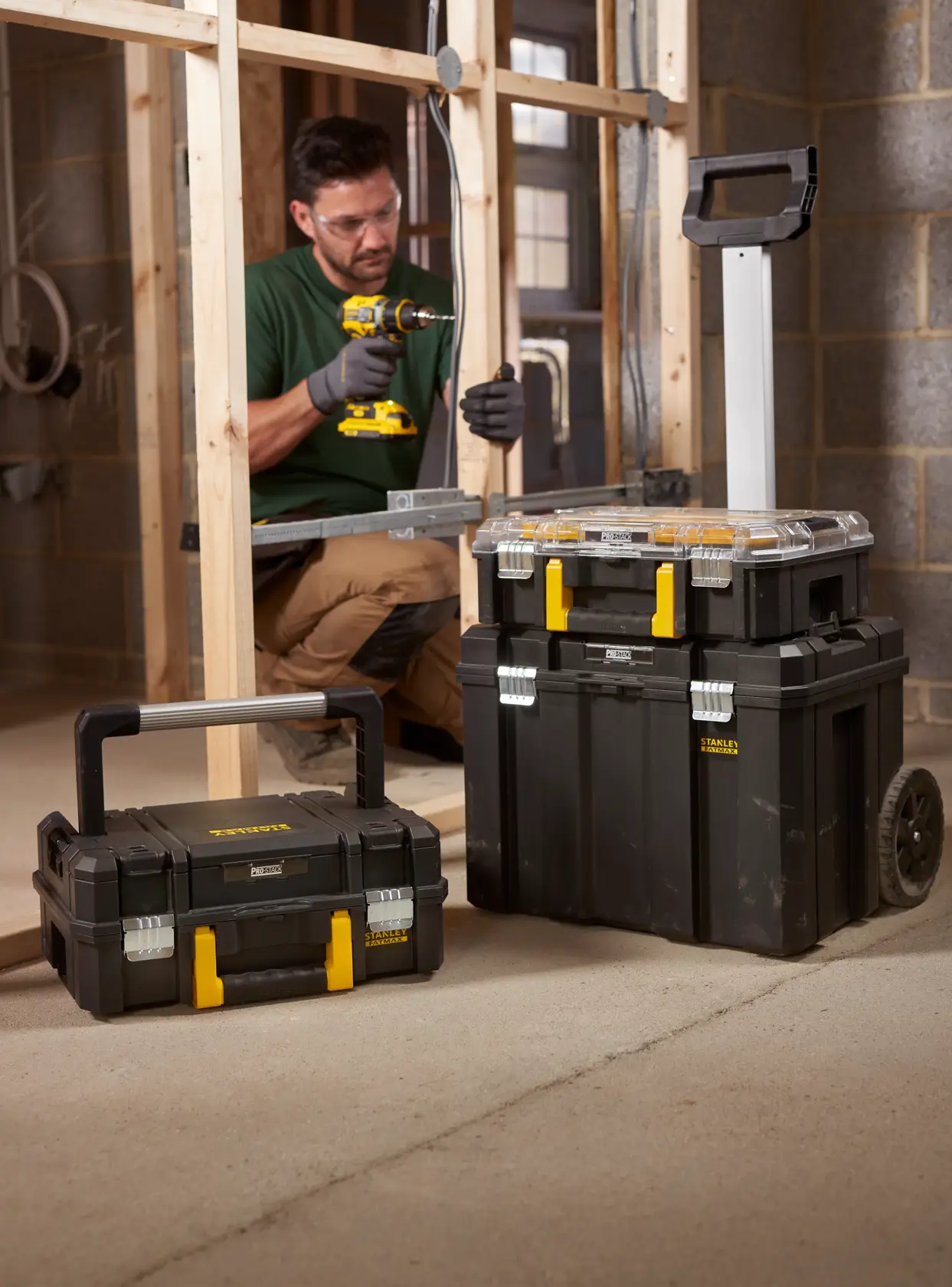 Valigie portautensili STANLEY FMST1-80103 impilabili nere con chiusure gialle e carrello con ruote, in cantiere.