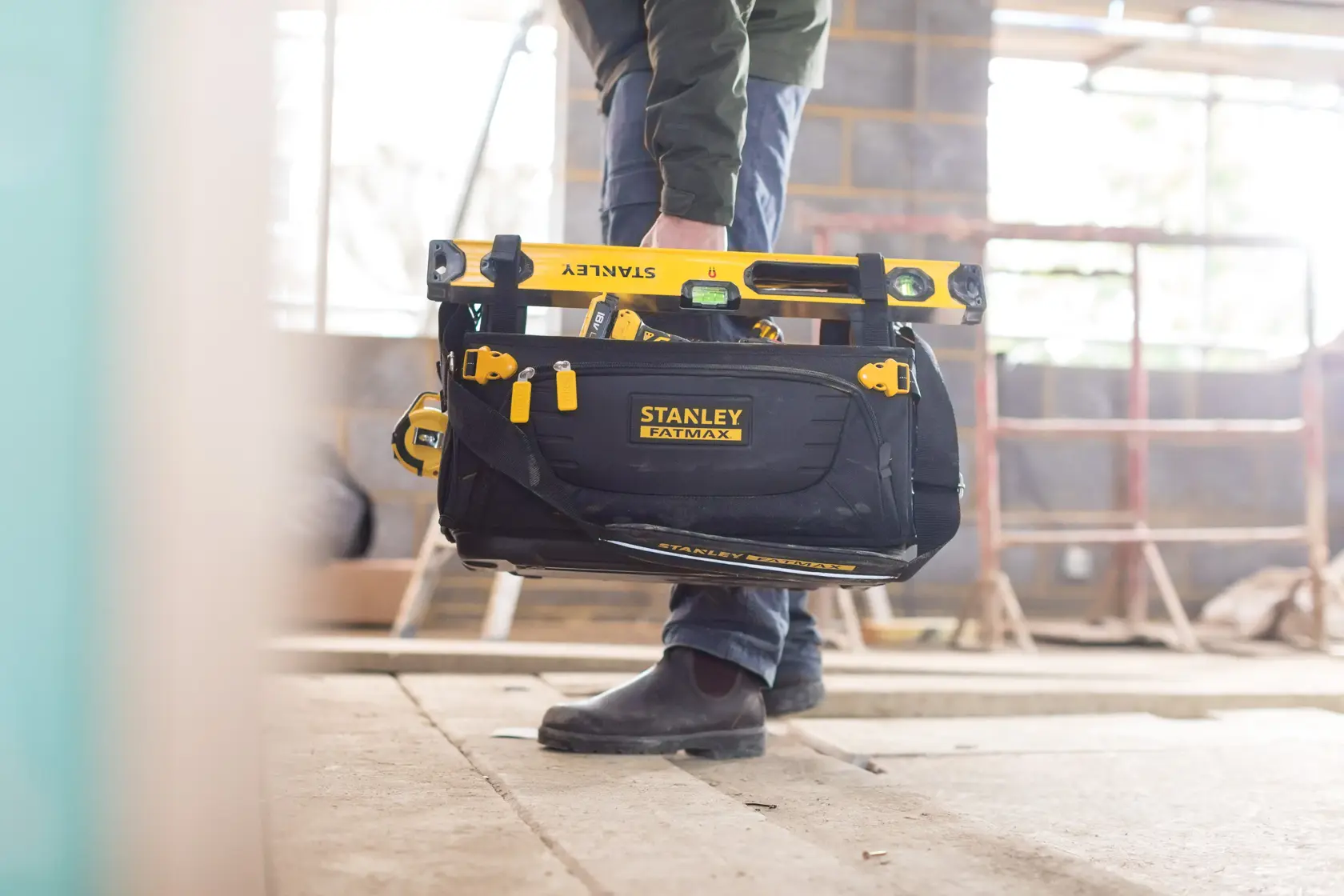 Foto della borsa per attrezzi STANLEY FMST1-80146 FATMAX con strumenti gialli in cantiere.