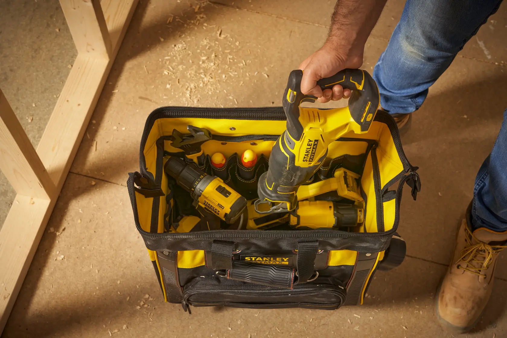 Foto della borsa portautensili STANLEY FMST1-80148 con utensili elettrici giallo-neri, vista dall’alto su un pavimento da laboratorio.