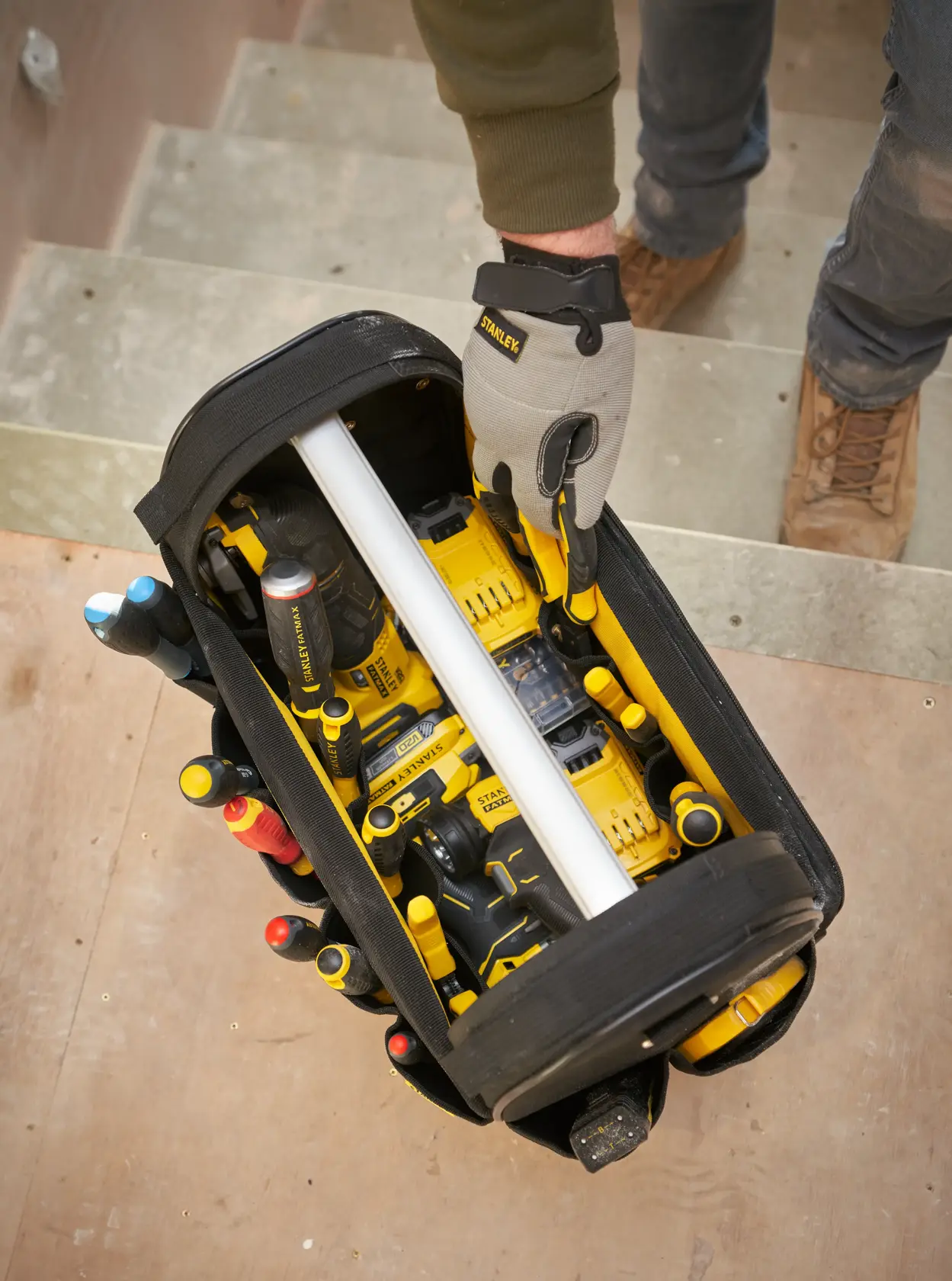 STANLEY FMST17626-1 fotografia di borsa porta attrezzi aperta con utensili elettrici gialli e attrezzi manuali vista dall'alto.