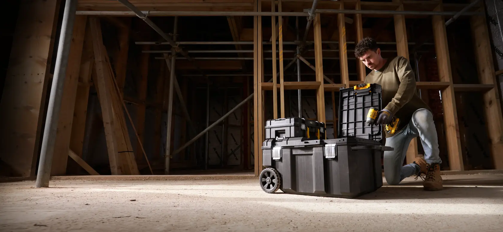 STANLEY FMST17870-1 cassette porta attrezzi con ruote impilate in cantiere, vista frontale, operaio inginocchiato.