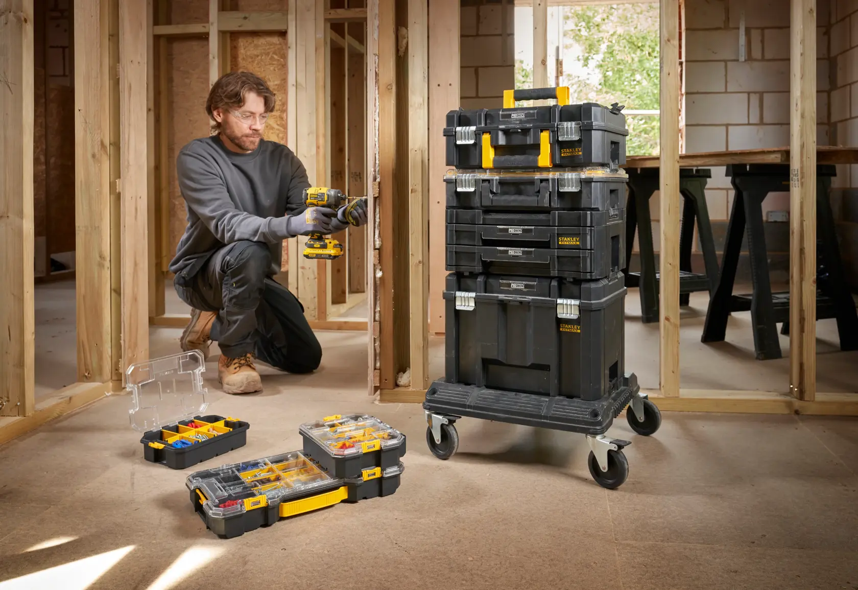 Cassette portautensili impilabili STANLEY FMST61150-1 su carrello con ruote e organizer aperti, mostrati in un cantiere.