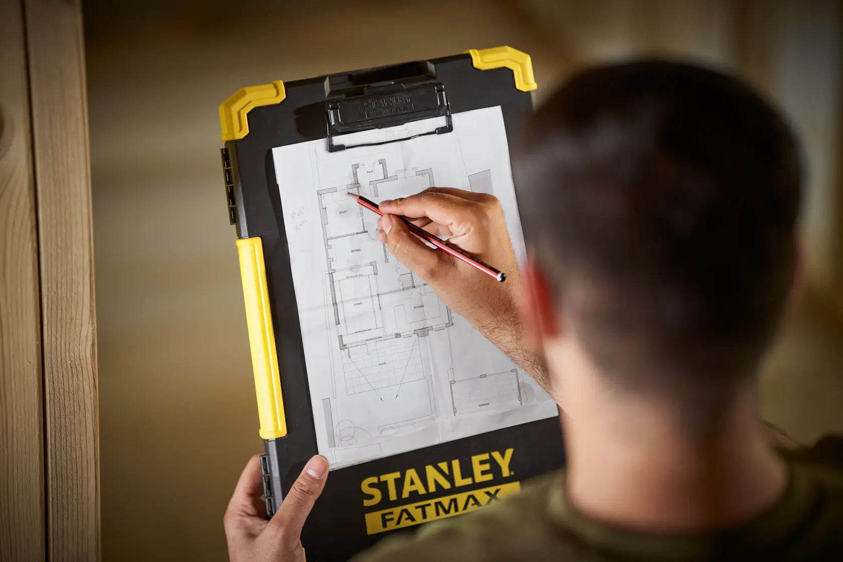Clipboard STANLEY FMST82721-1 con manico giallo, usata per segnare un piano architettonico.