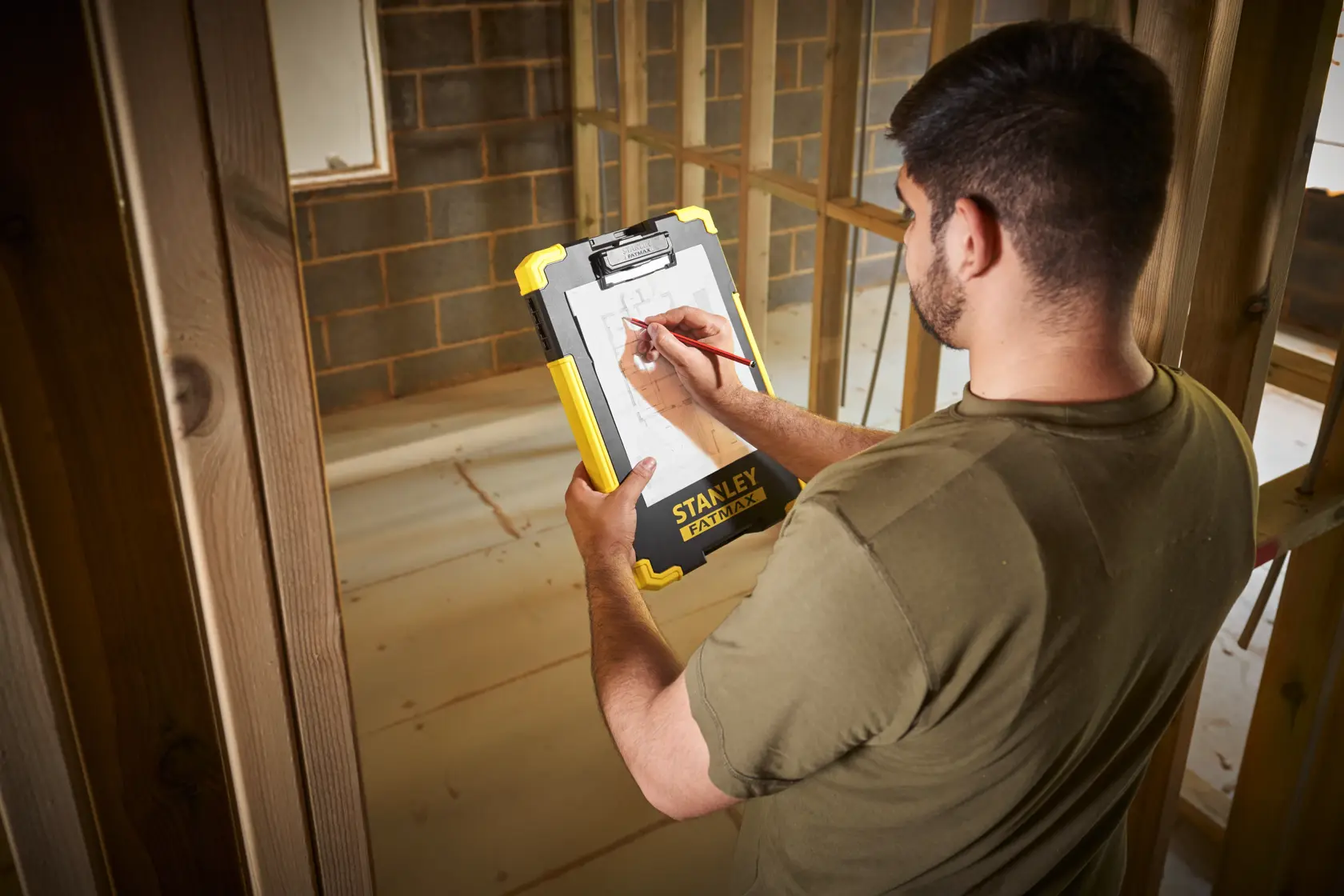 Foto del clipboard STANLEY FMST82721-1 tenuto in cantiere, design resistente giallo e nero.
