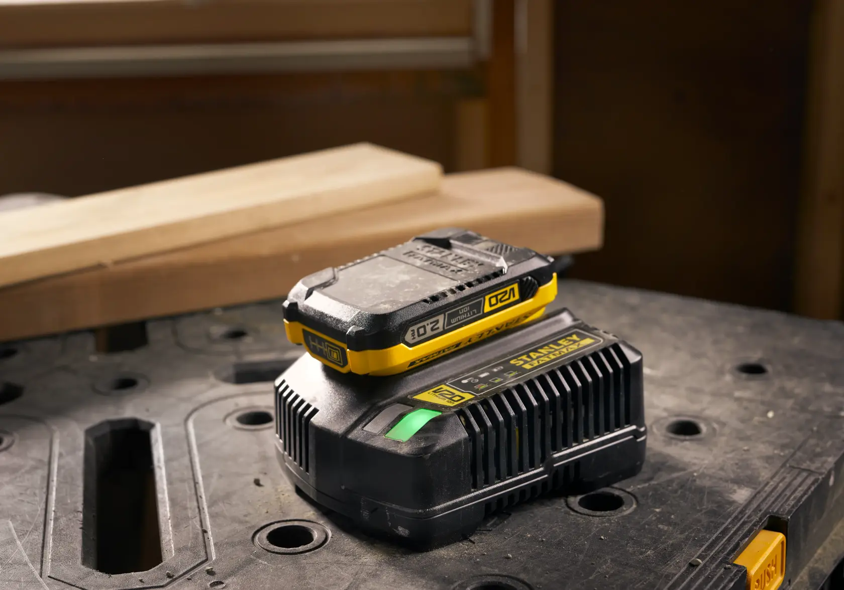 STANLEY SFMCB202 batteria e caricatore con dettagli gialli su banco da lavoro, vista frontale.