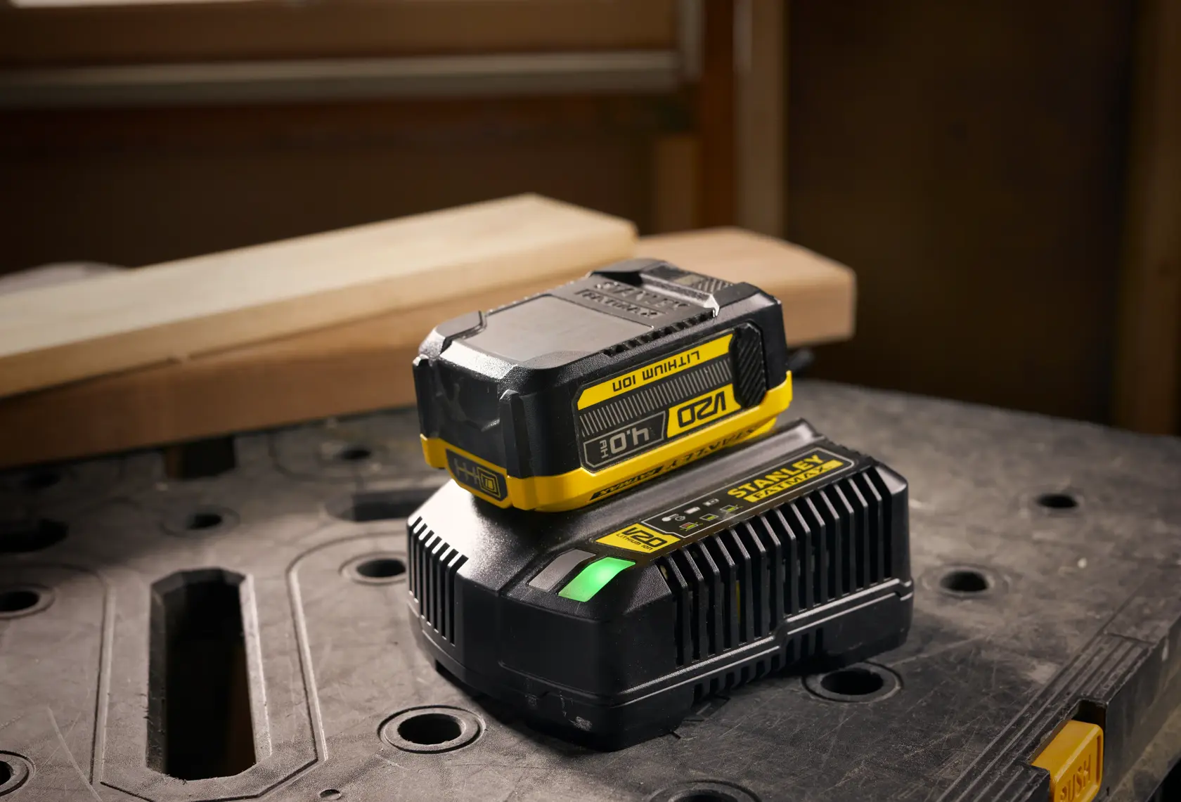 STANLEY SFMCB204 batteria e caricabatterie, nero e giallo, su tavolo da lavoro, fotografia prodotto.