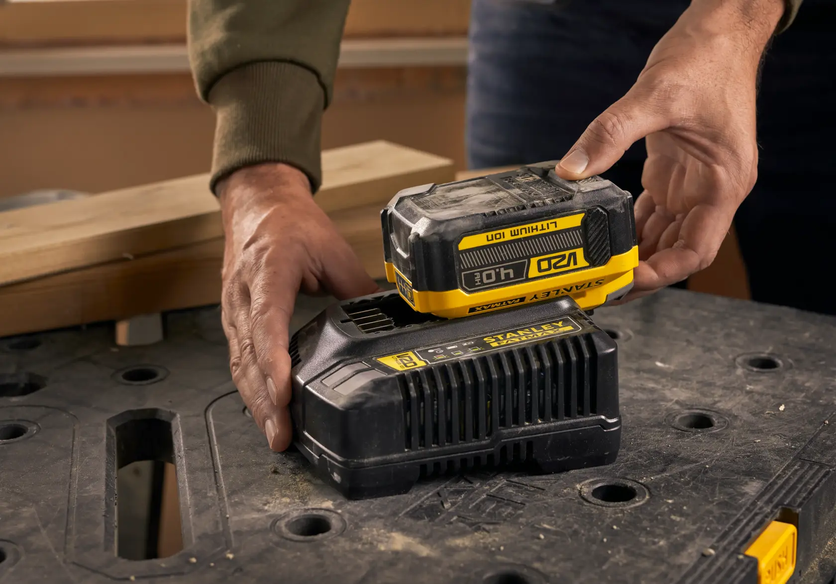 Fotografia della batteria STANLEY SFMCB204 posizionata sul caricabatterie su banco da lavoro.