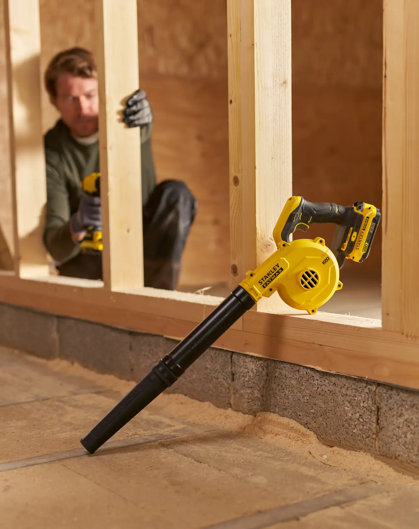 STANLEY SFMCBL01B soffiatore a batteria su telaio in legno, design giallo e nero, ambiente da cantiere interno.