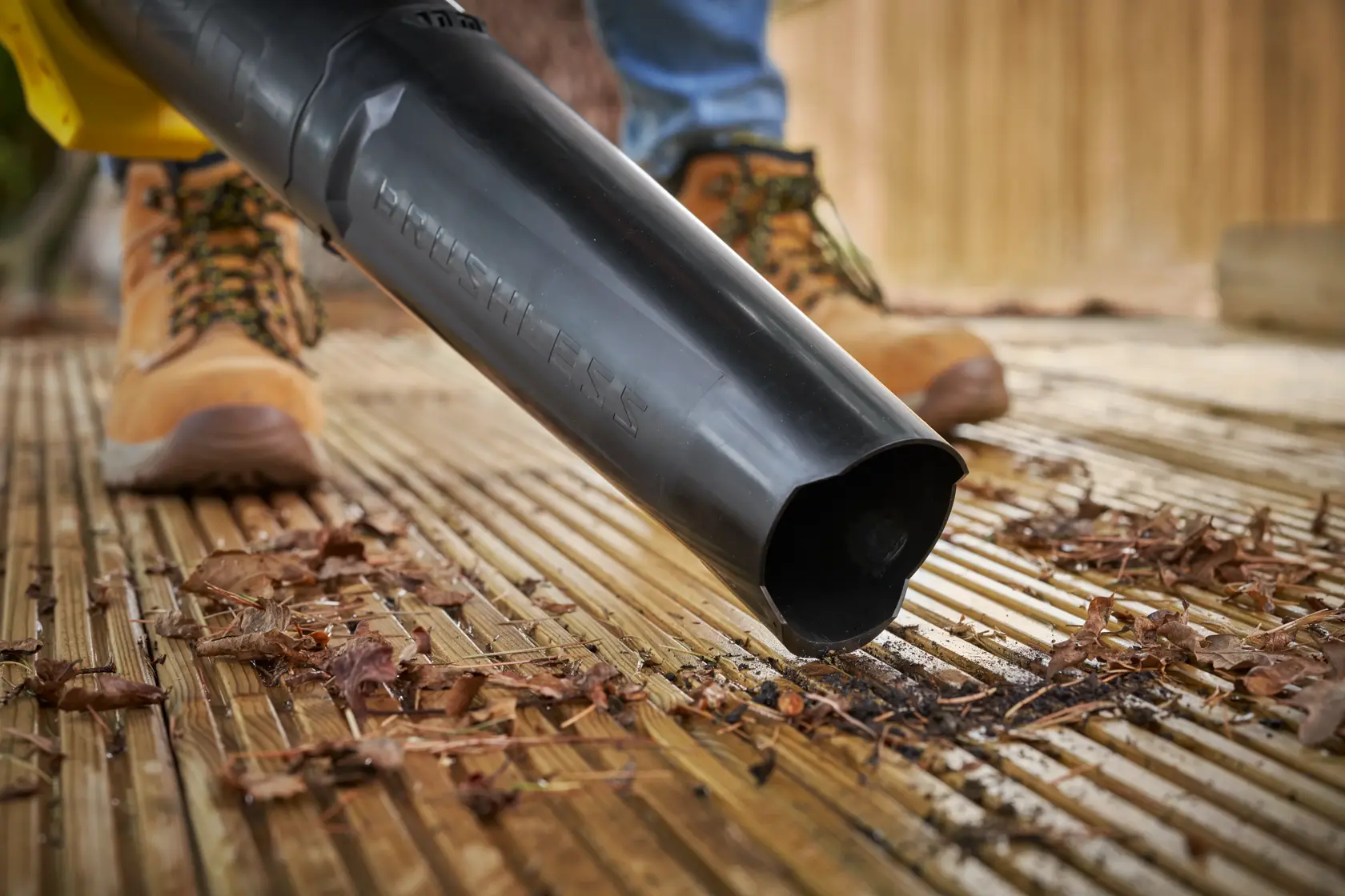 STANLEY SFMCBL730M1 soffiatore di foglie in azione su terrazza in legno, primo piano dell'ugello.