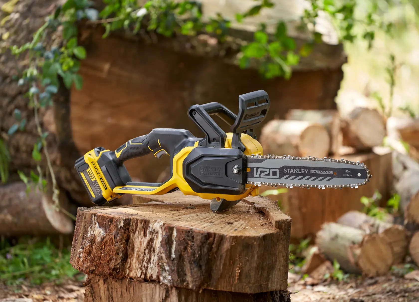 STANLEY SFMCCS730B motosega senza fili gialla e nera appoggiata su un ceppo all’aperto.