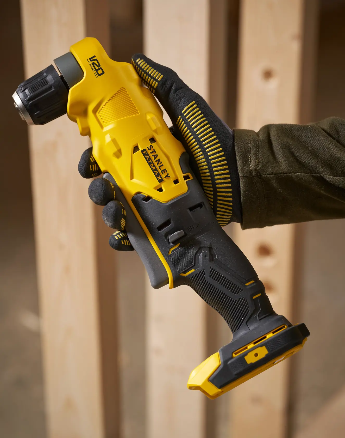 Stanley SFMCD750B trapano angolare cordless giallo e nero, tenuto con guanto, ambiente di costruzione.