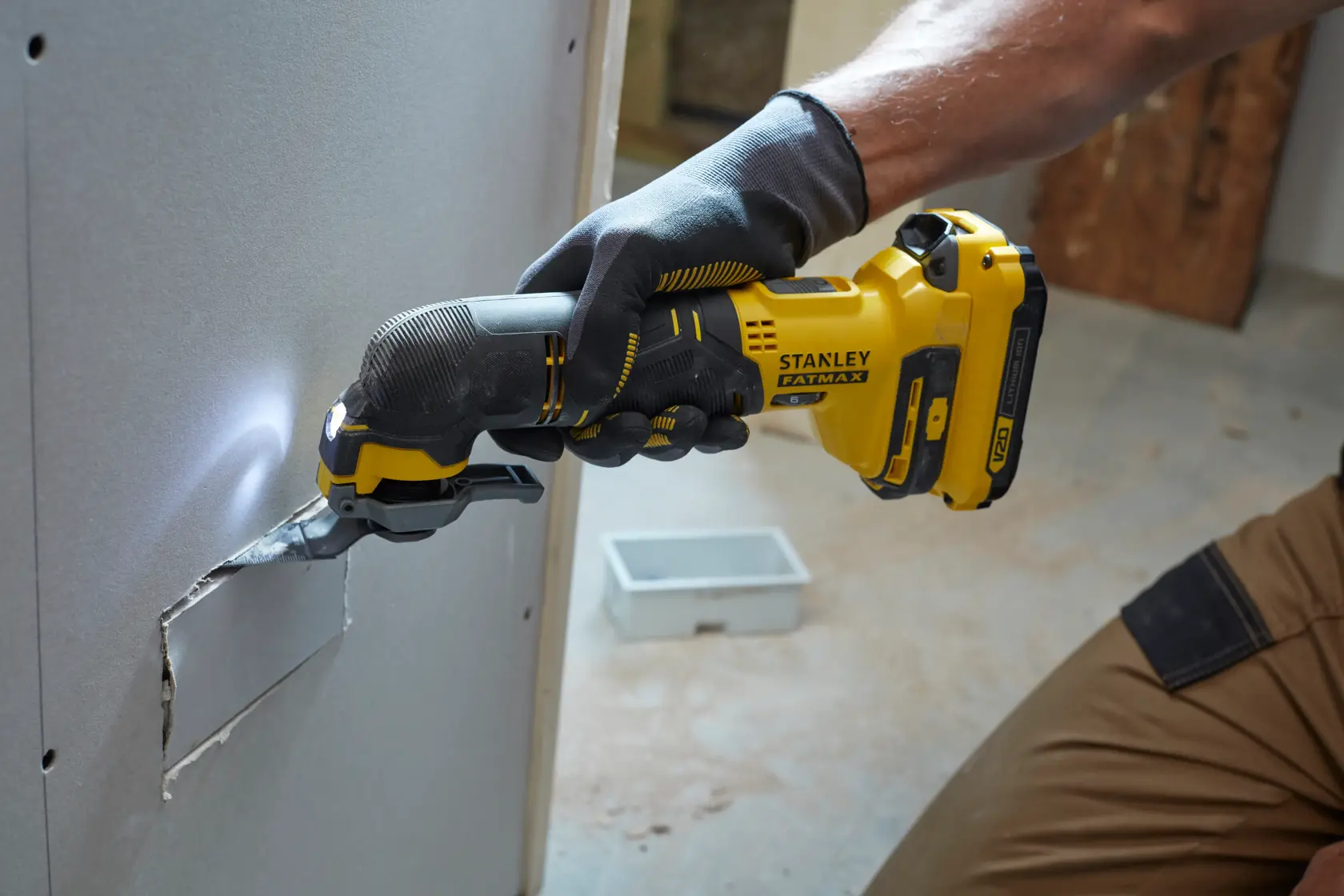 STANLEY SFMCE500B multiutensile oscillante taglia cartongesso, lavoratore con guanti, design giallo e nero.